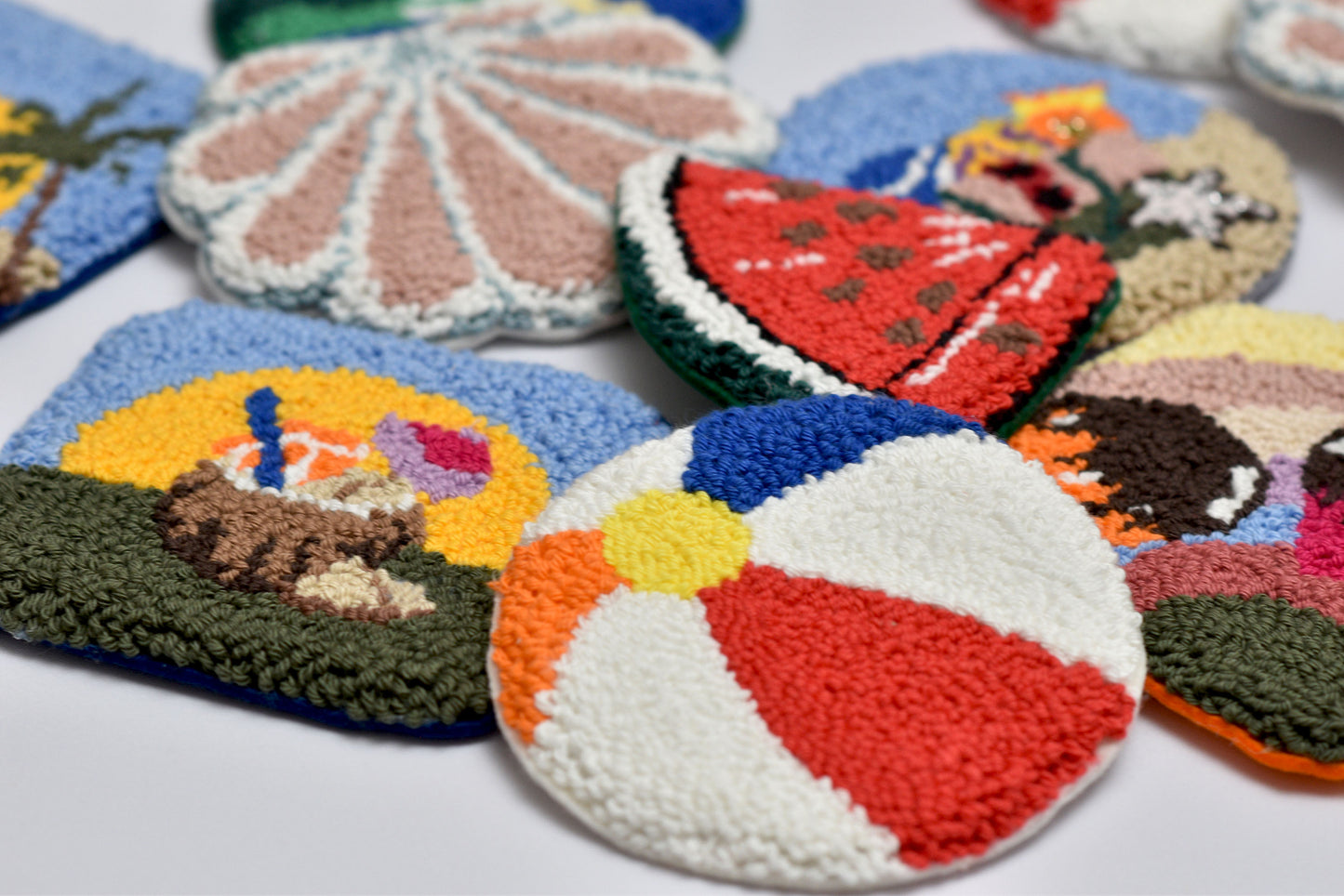 Colorful knitted coasters with various designs on a white surface