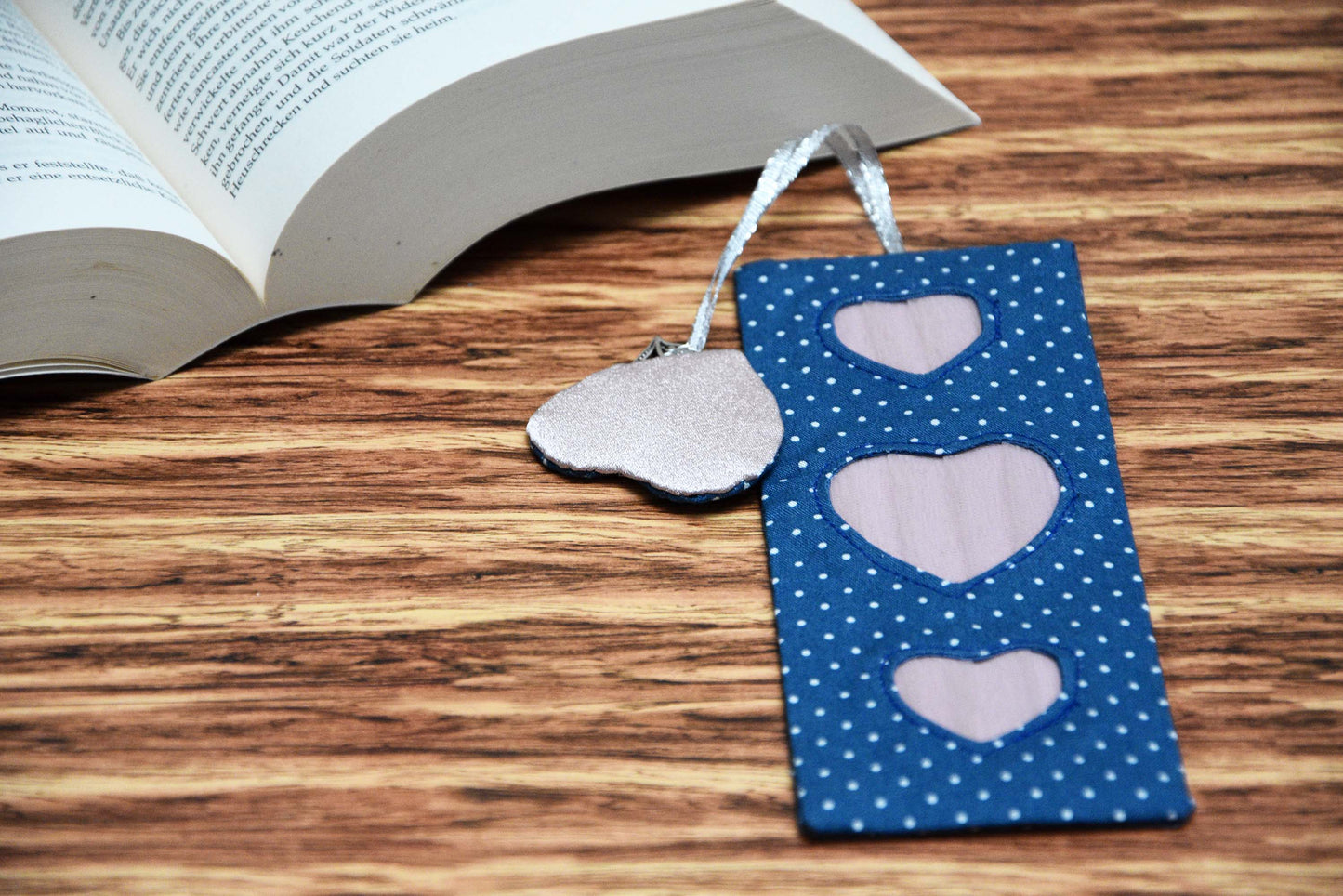 Page Marker with Heart Tassel with a book open at the background