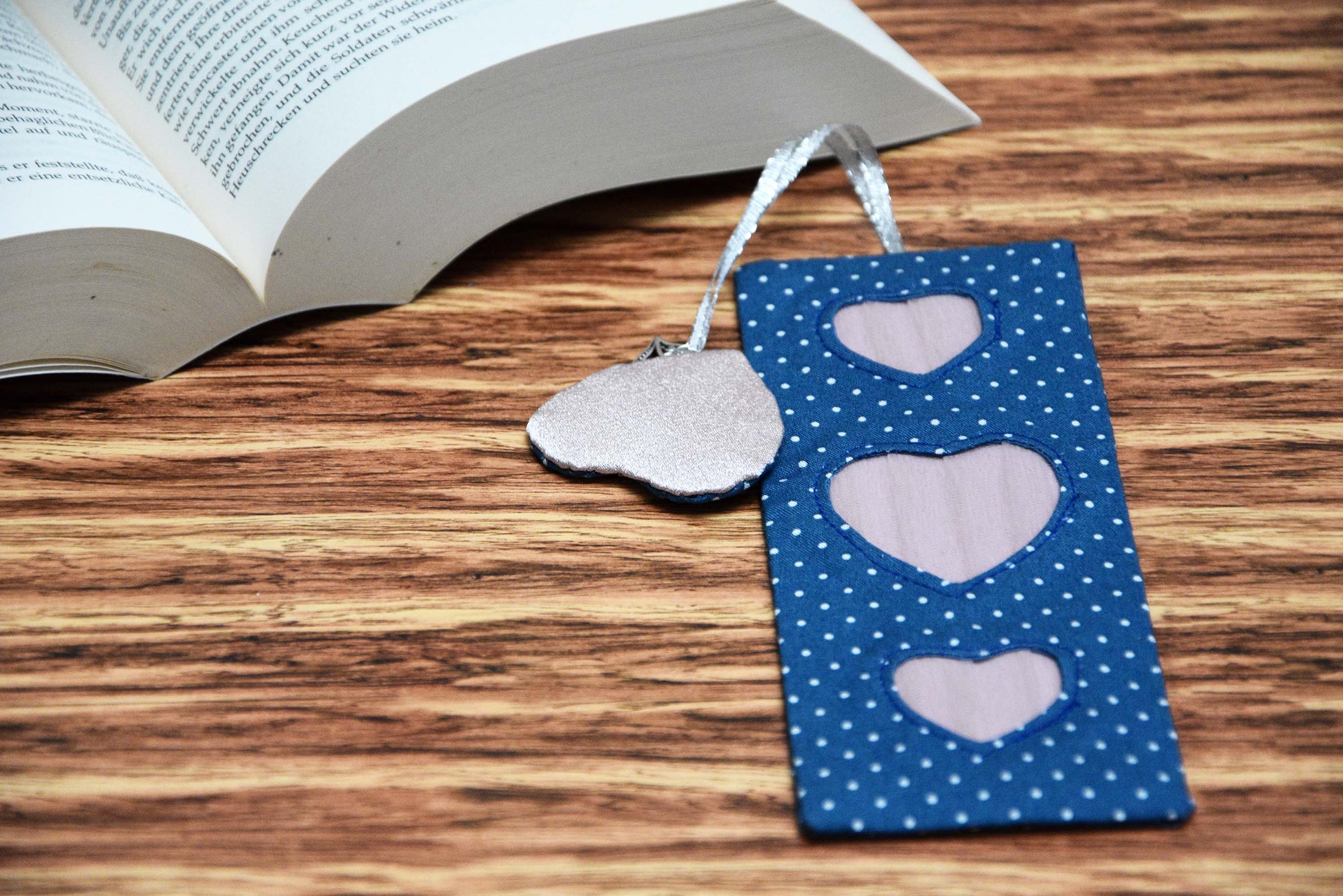 Page Marker with Heart Tassel with a book open at the background