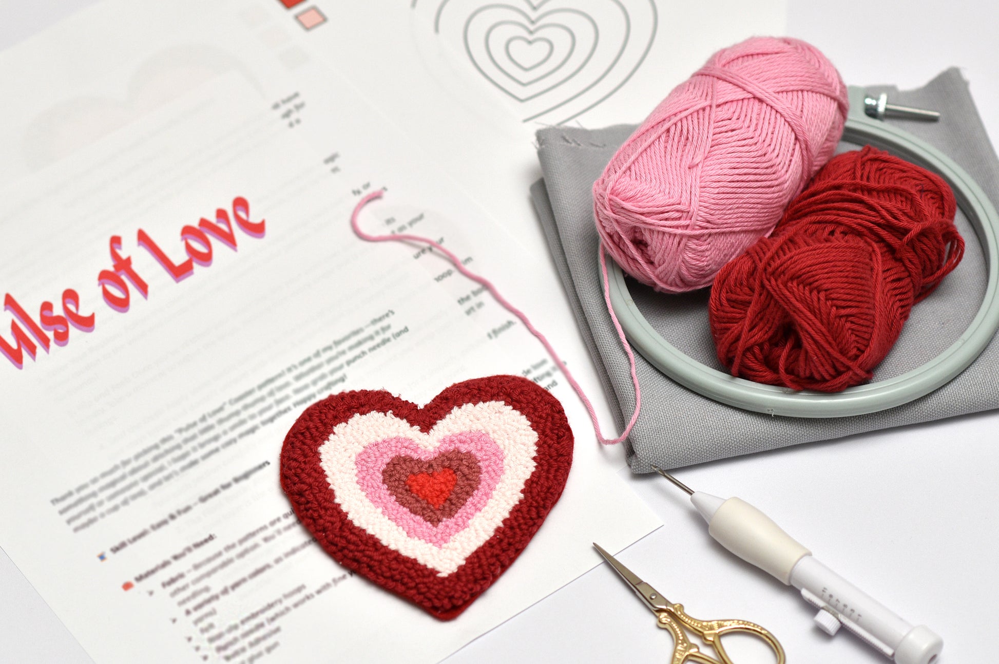 Heart-shaped crochet project with yarn and tools on a table