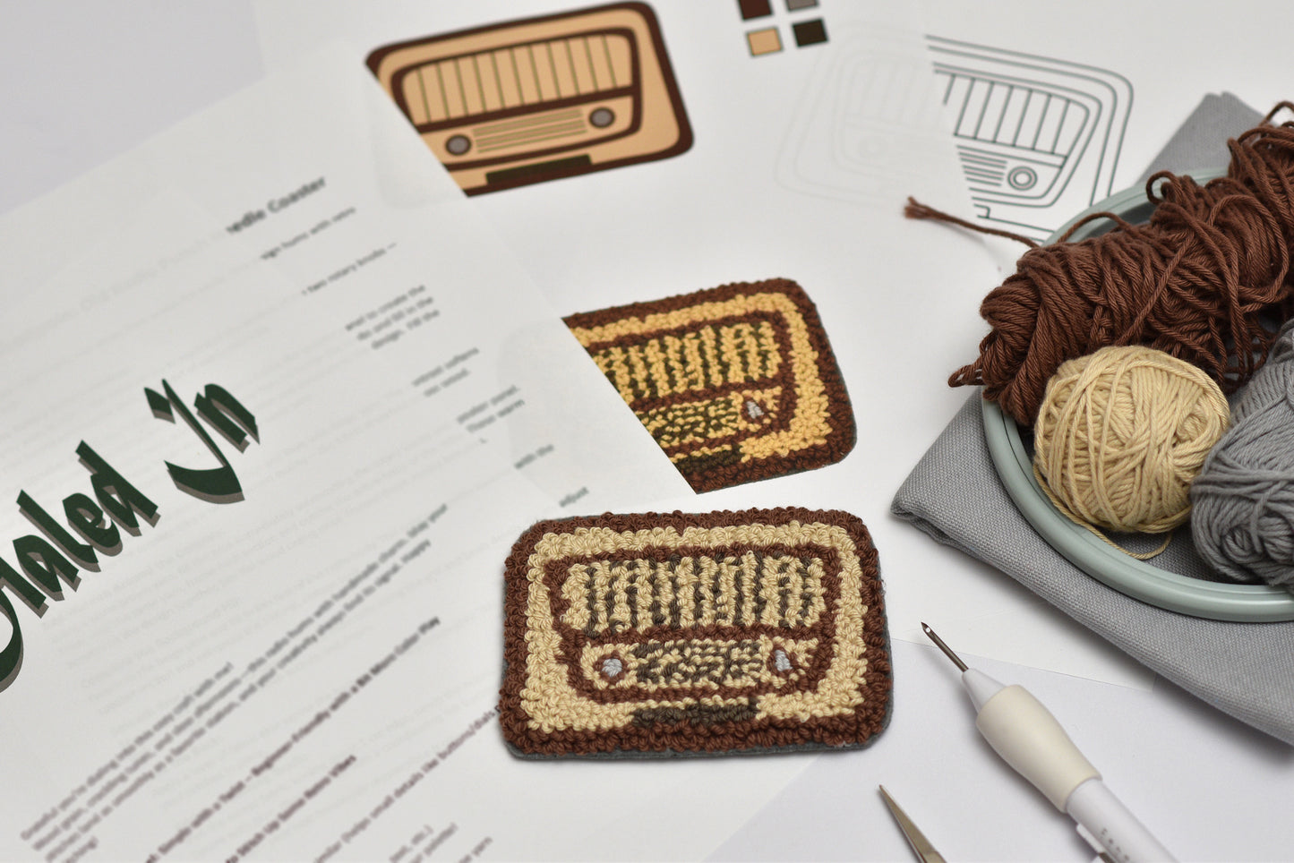 Embroidered radio designed coaster patterns on a sheet of paper with yarn and crochet tools.