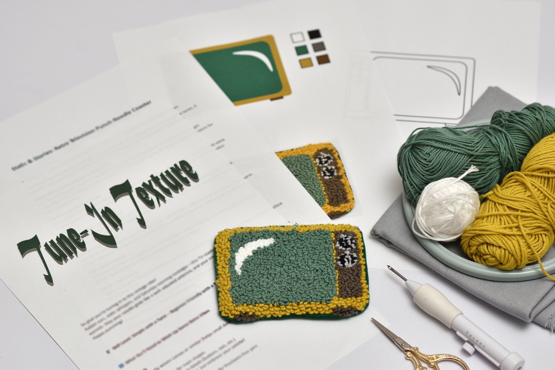 Embroidery coaster design project with embroidered coaster, yarn, and tools on a table.