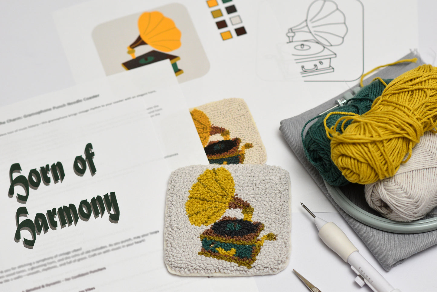 Horn of Harmony themed gramophone designed coaster punch needle project with yarn and tools on a table