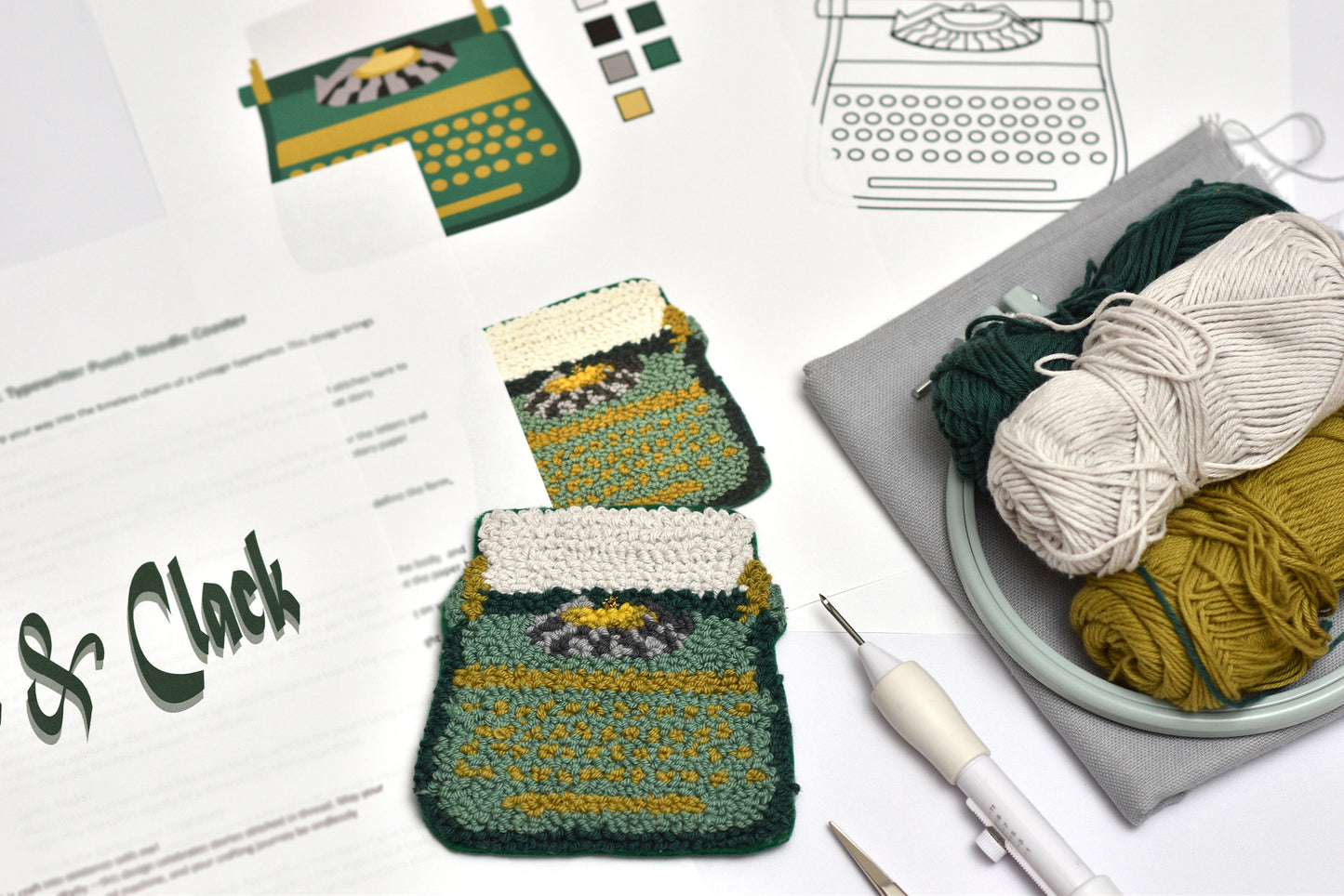 Punch needled coaster with a typewriter design on a table with yarn and knitting tools.