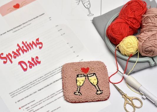 Handmade coaster with champagne design on a table with yarn and scissors