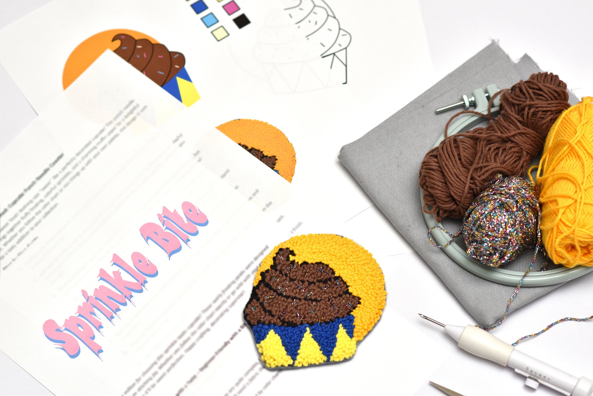 Cupcake-shaped punch needle project with yarn and tools on a table