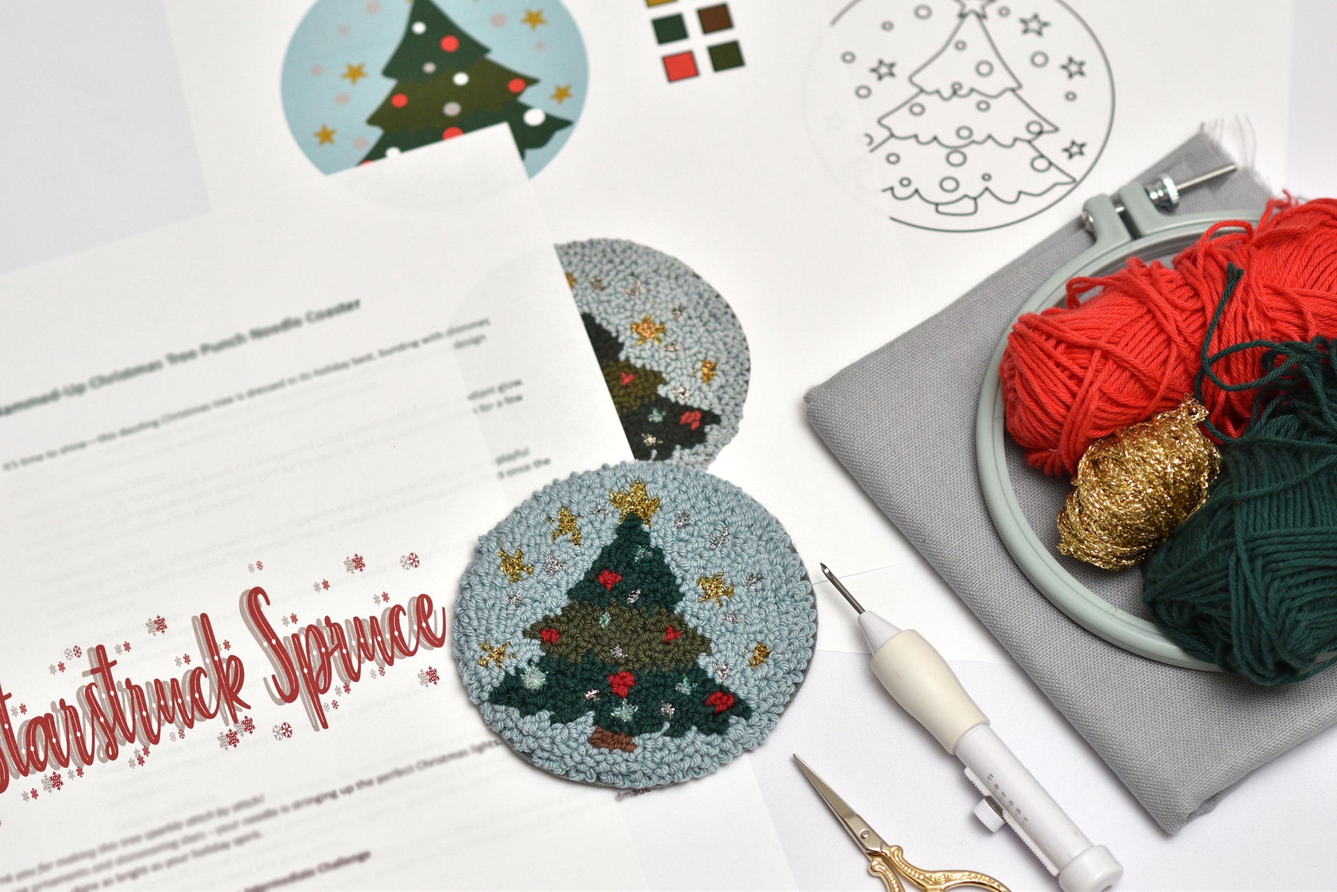Yarn and craft materials with Christmas-themed punch needle coasters and a pattern sheet on a white surface.