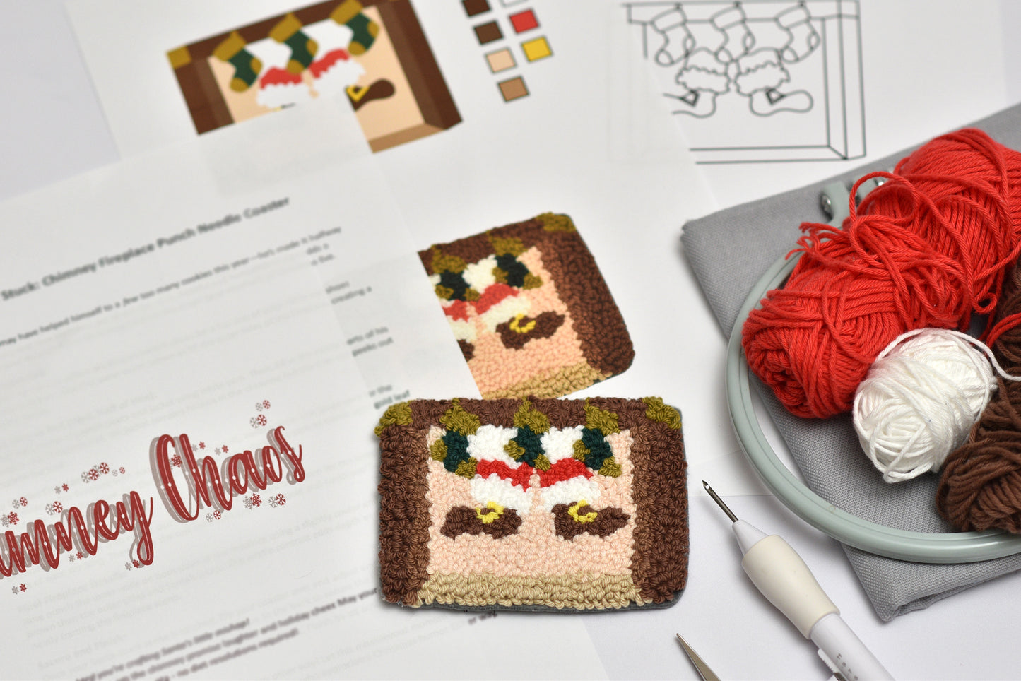 Punch needled Christmas-themed coasters with yarn and knitting tools on a table.