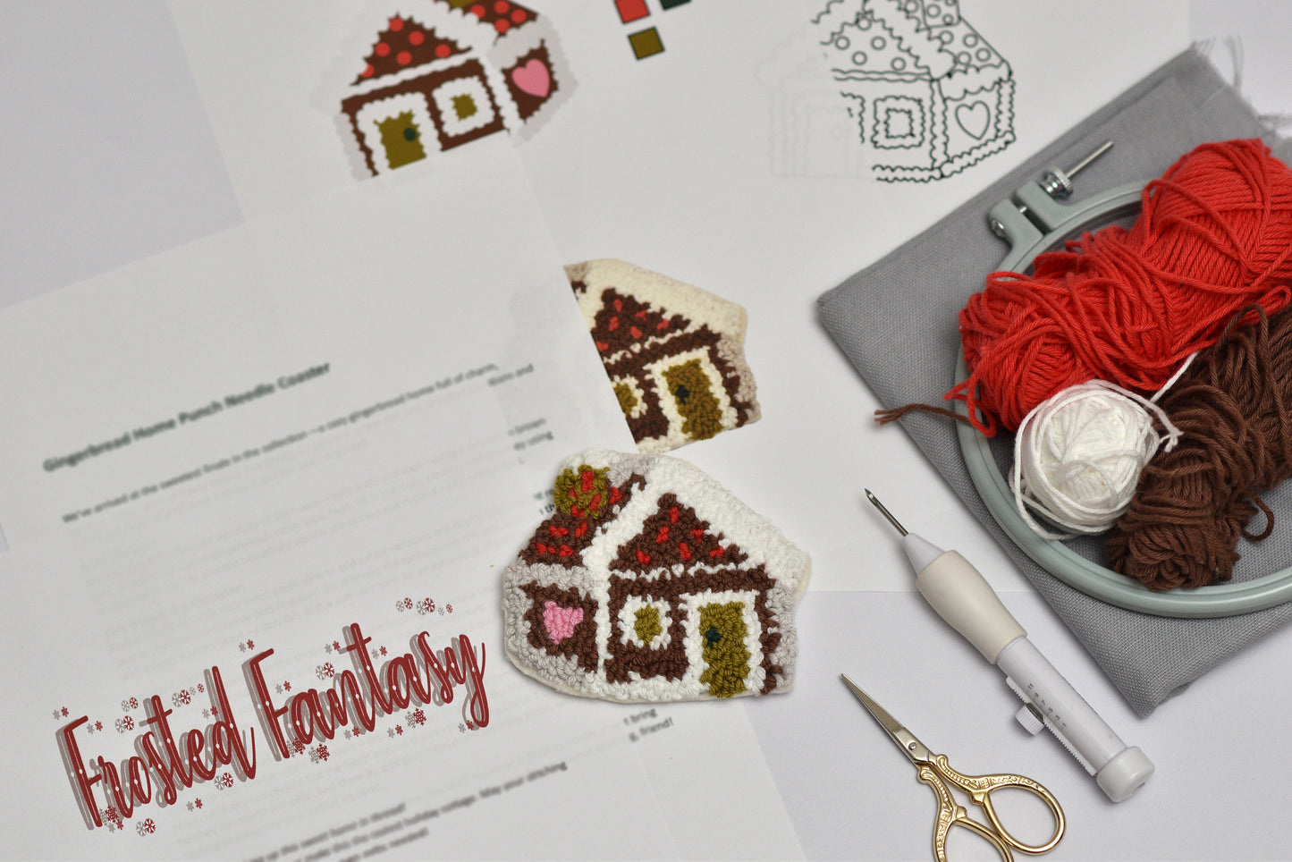 Punch needled gingerbread house digital kit with yarn, scissors, and pattern sheet on a light background