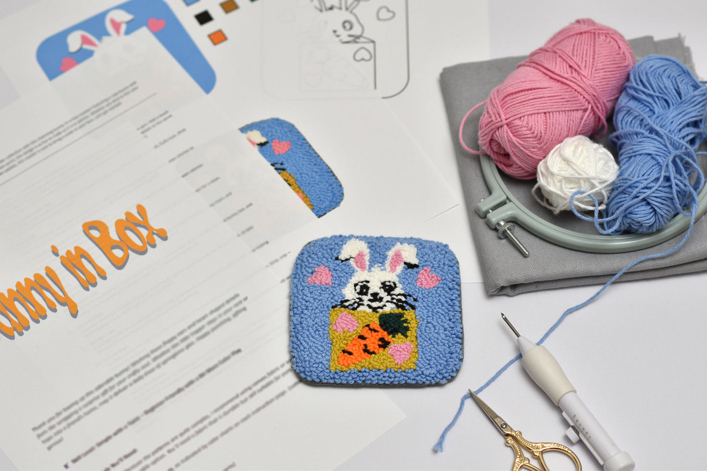Embroidered coaster of an Easter Bunny in a box with yarn and tools on a table