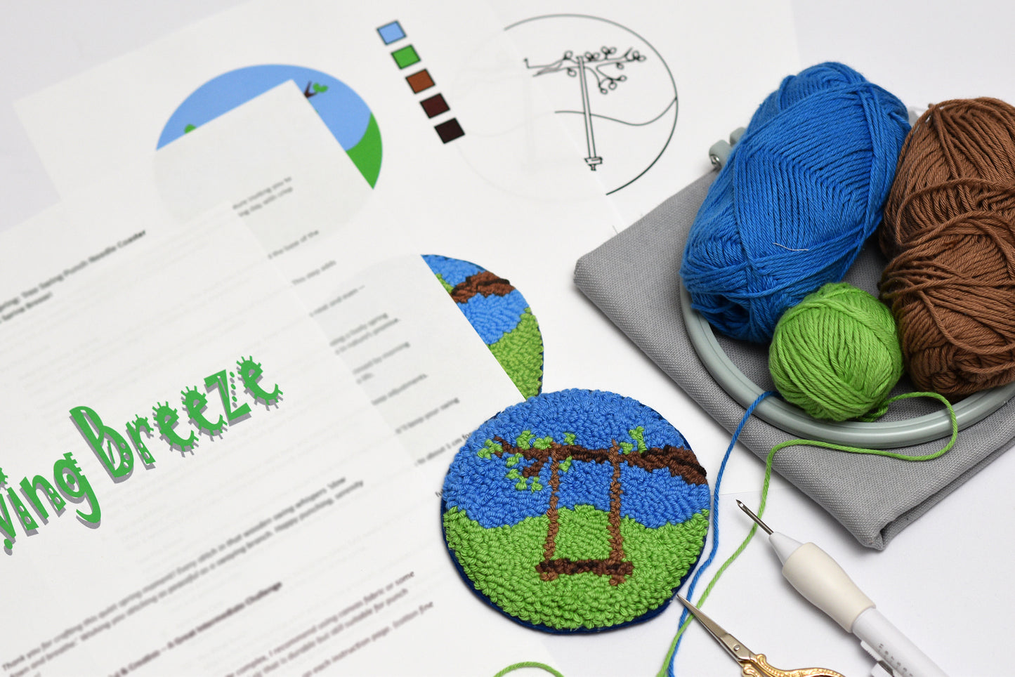 Embroidery hoop with yarn and completed embroidery coaster with swing design on a flat surface.