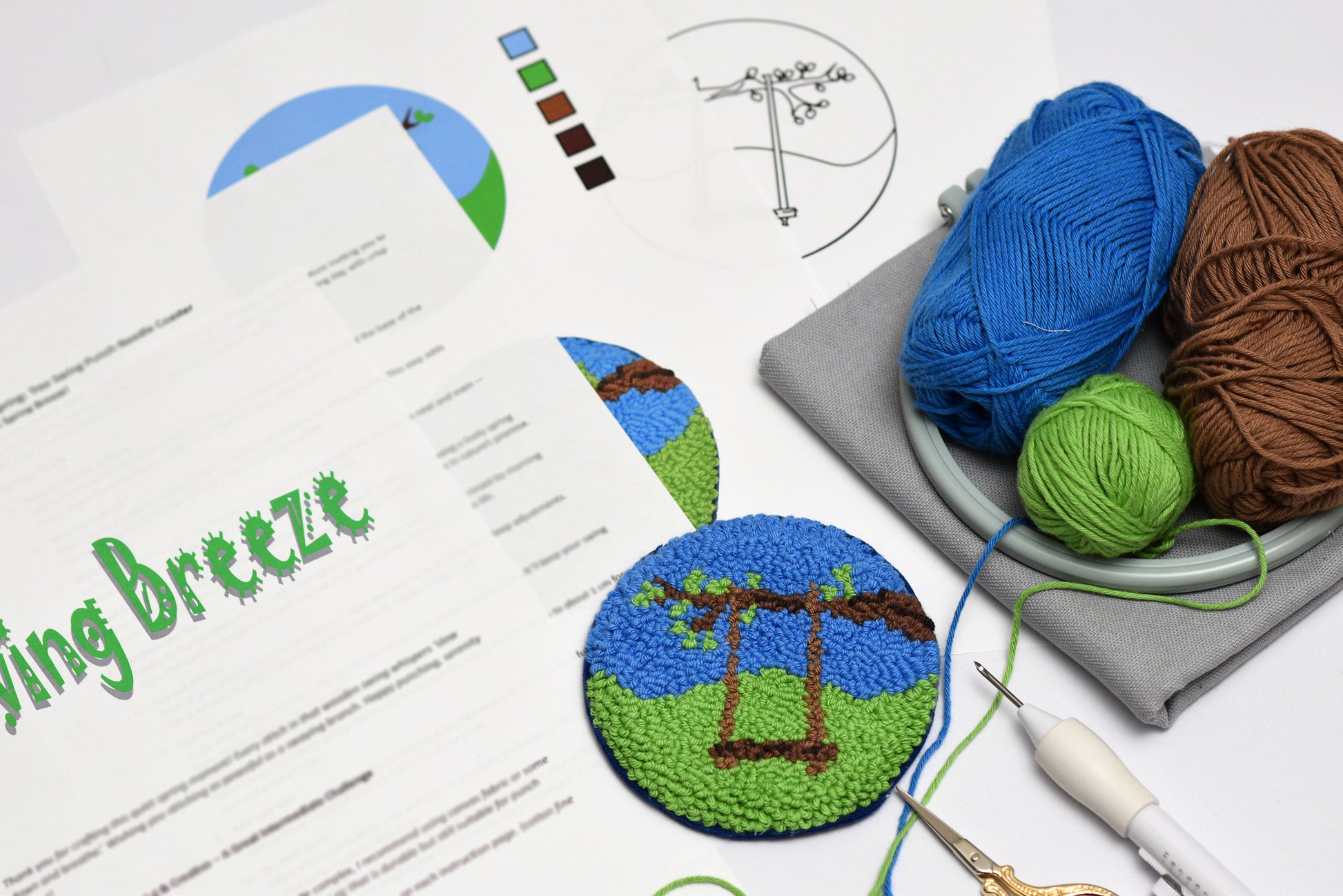 Embroidery hoop with yarn and completed embroidery coaster with swing design on a flat surface.