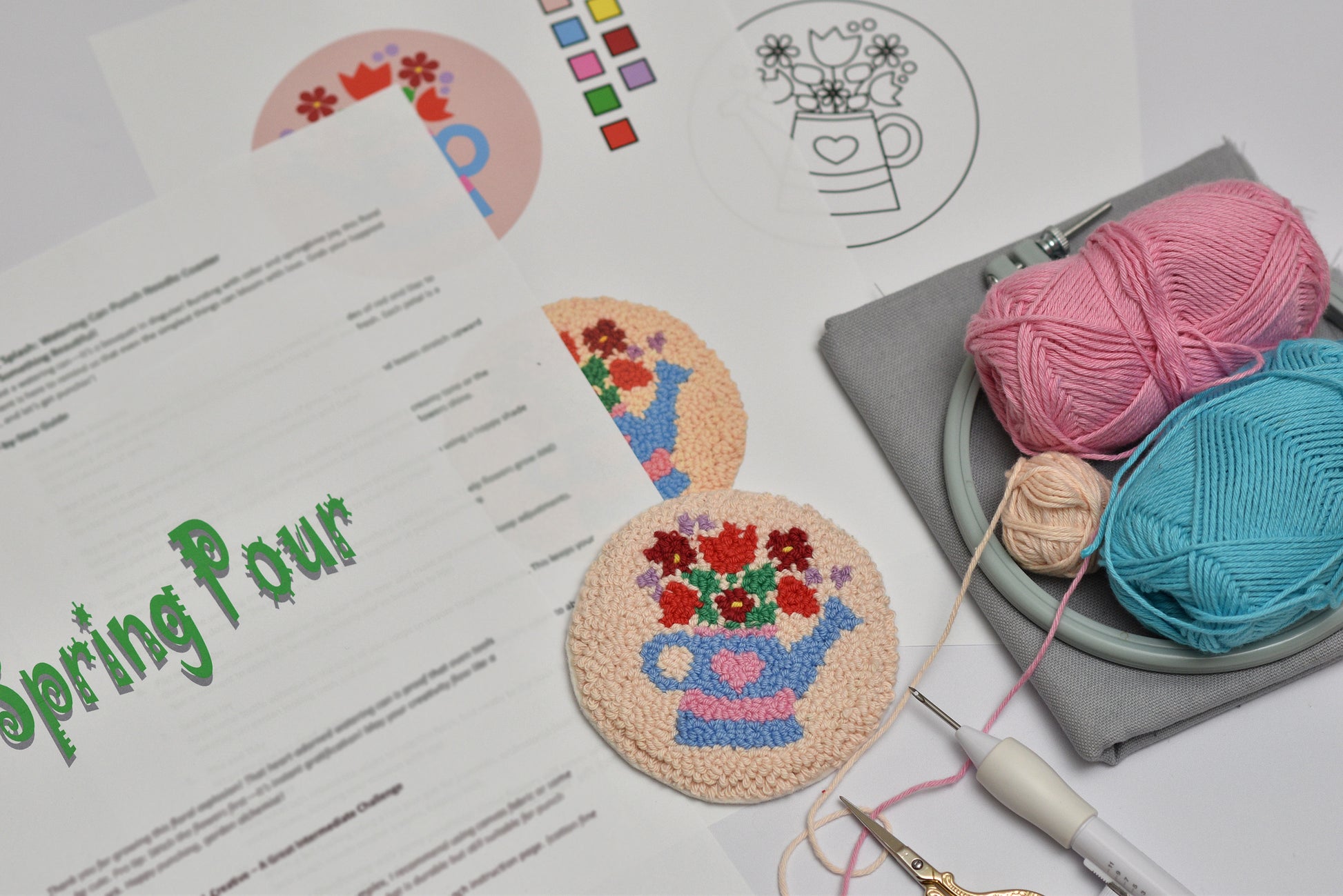 Crafting materials including yarn and coasters with floral designs on a table.