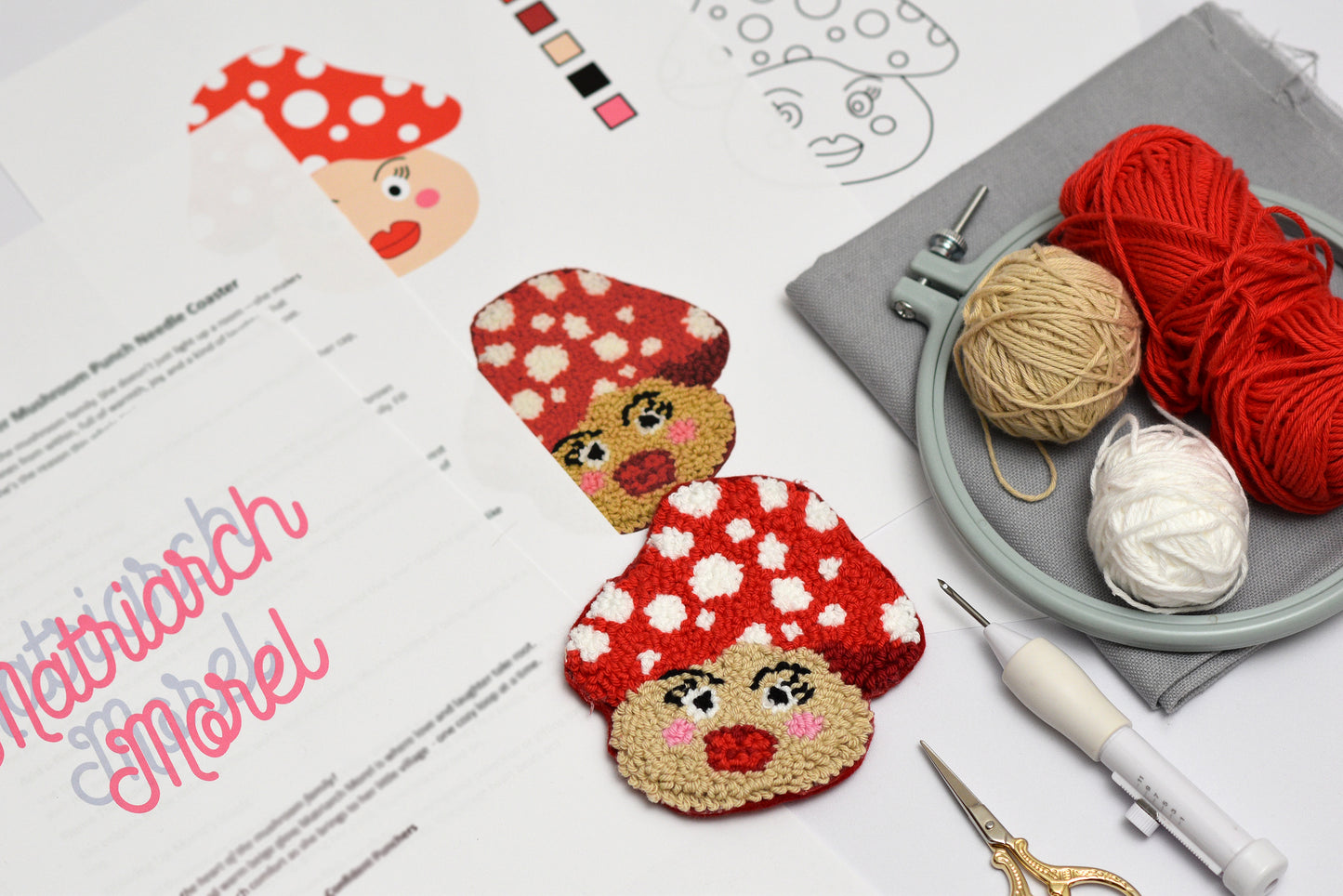 Punch needled mushroom-shaped coasters with yarn and knitting tools on a table.