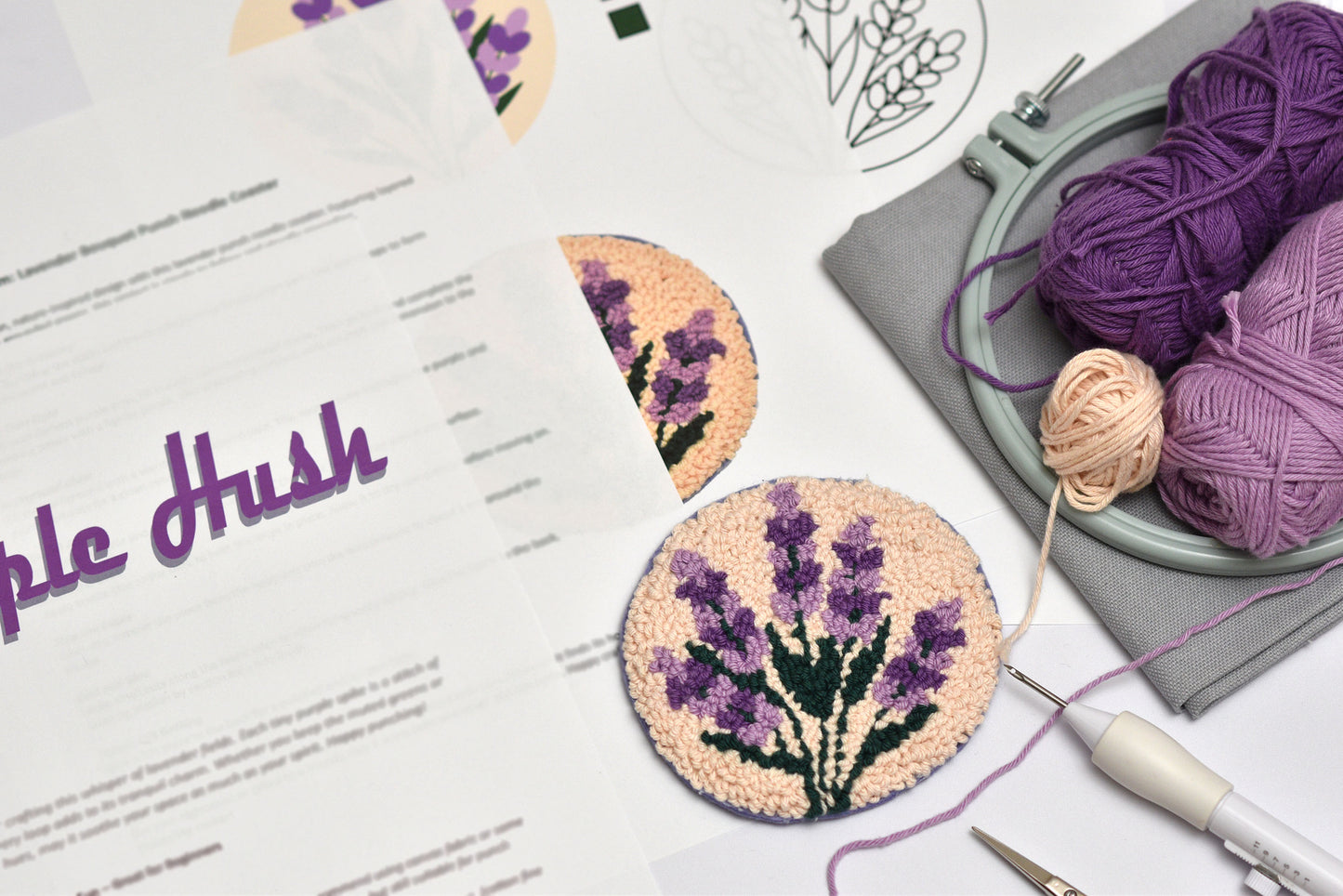 Embroidery hoop with lavender-themed coaster, yarn, and 'Purple Hush' branding.