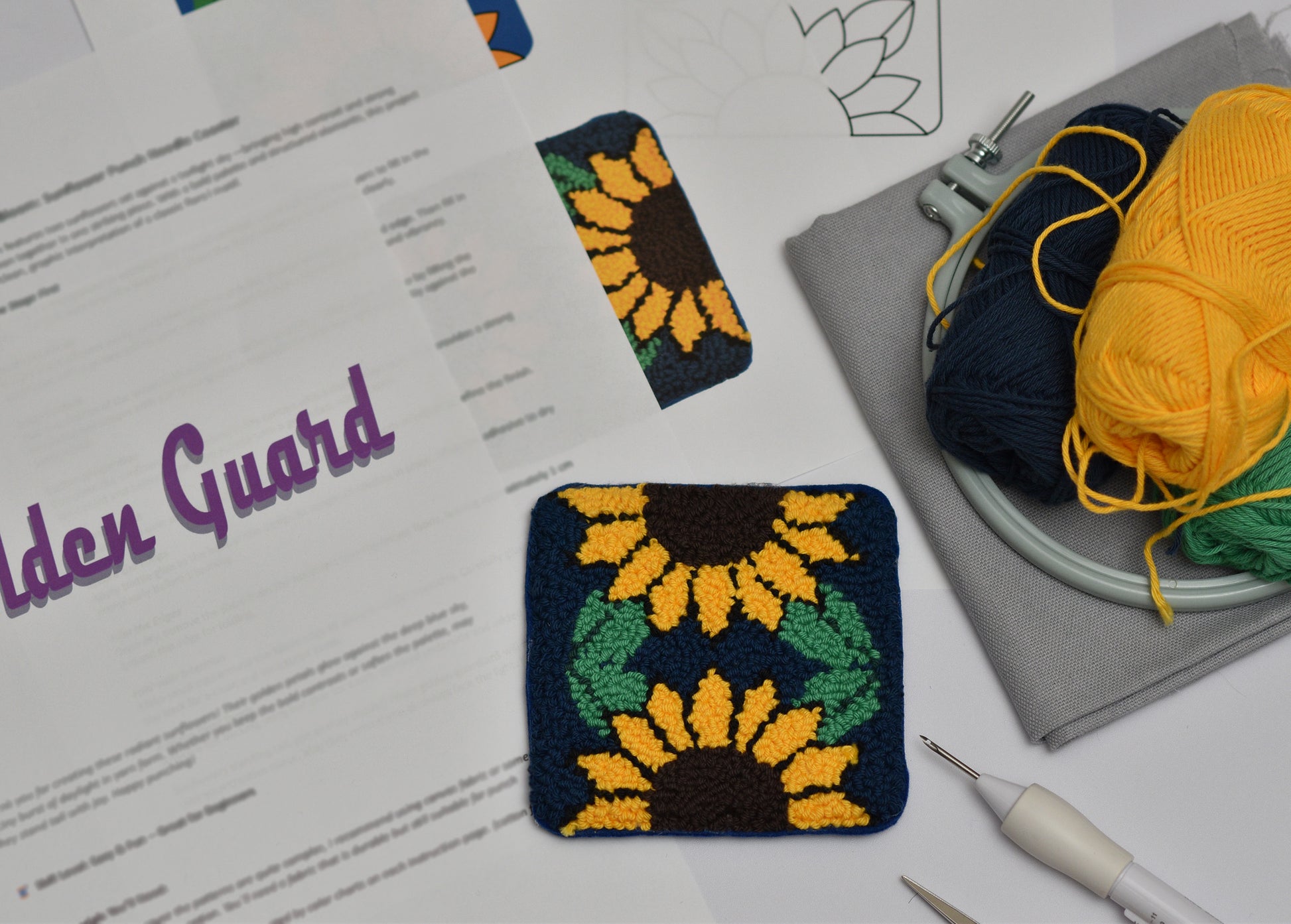 Sunflower-themed coaster swatch on a white surface with yarn and tools.