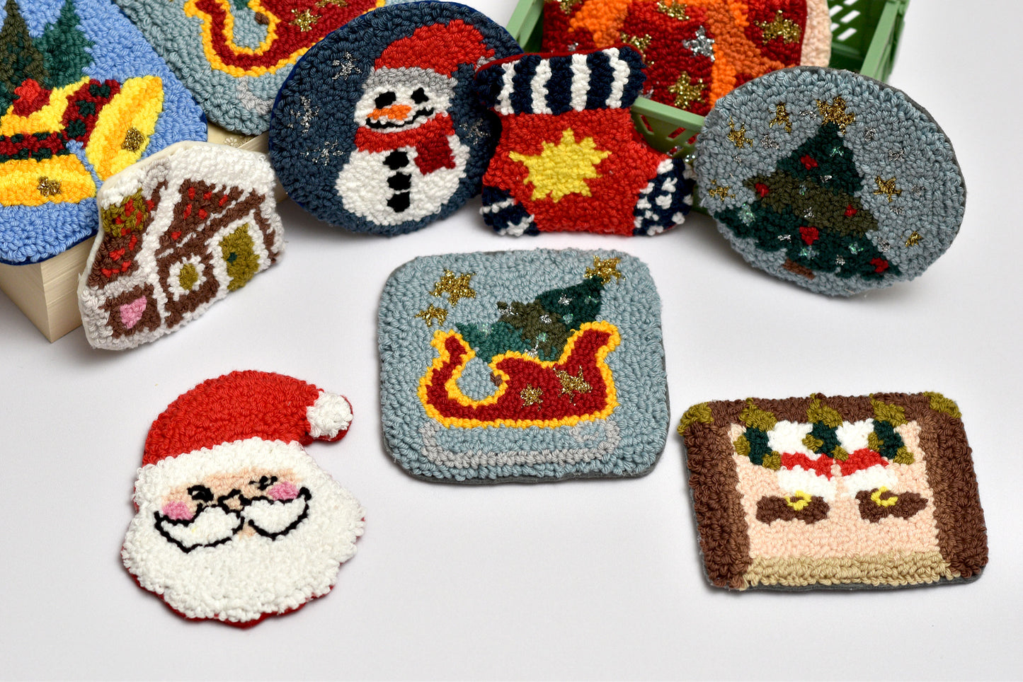 Decorative punch needle coasters with christmas themed designs on a white background
