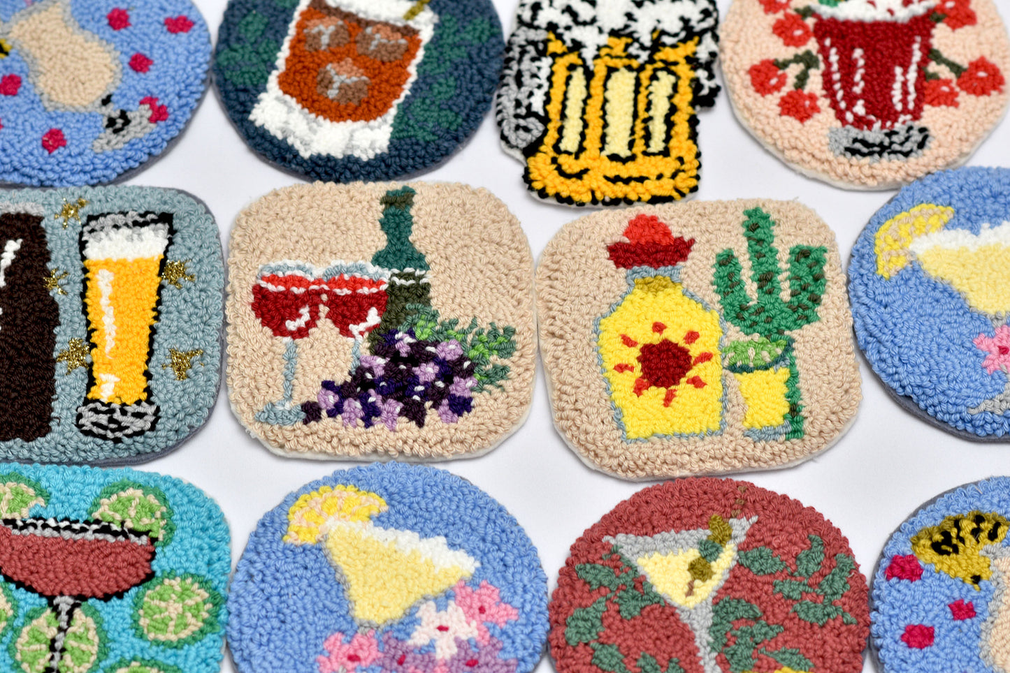 Collection of colorful coasters with various drink designs on a white background