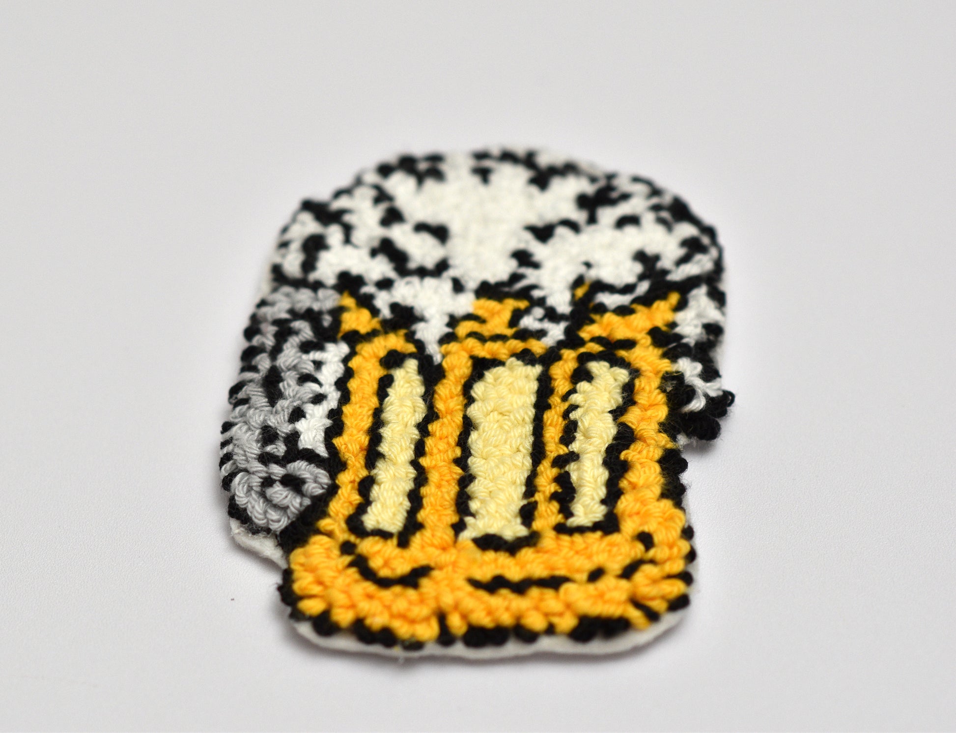 Embroidered coaster with a beer mug design on a gray background