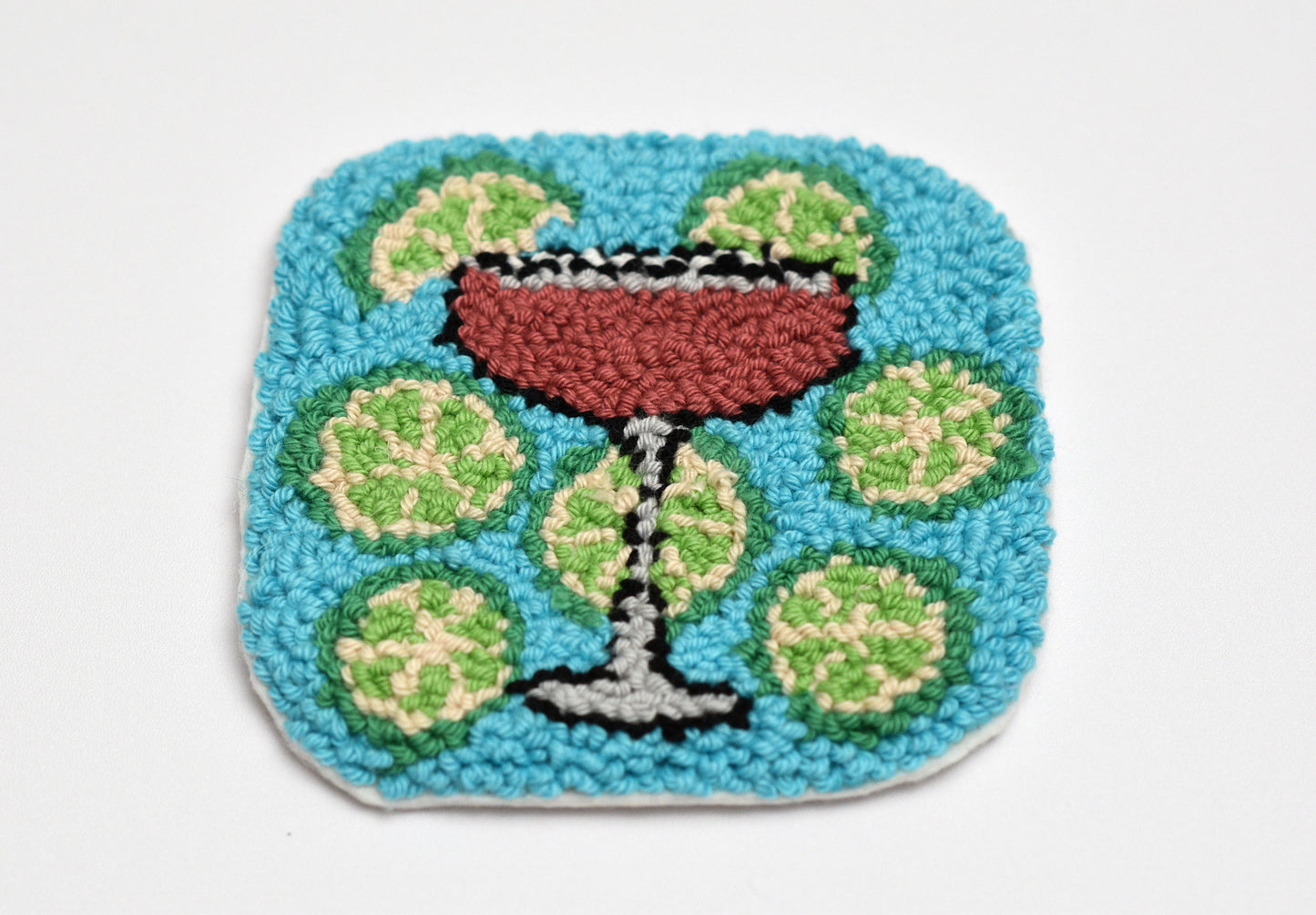 Decorative coaster with a cosmopolitan cocktail design on a white background