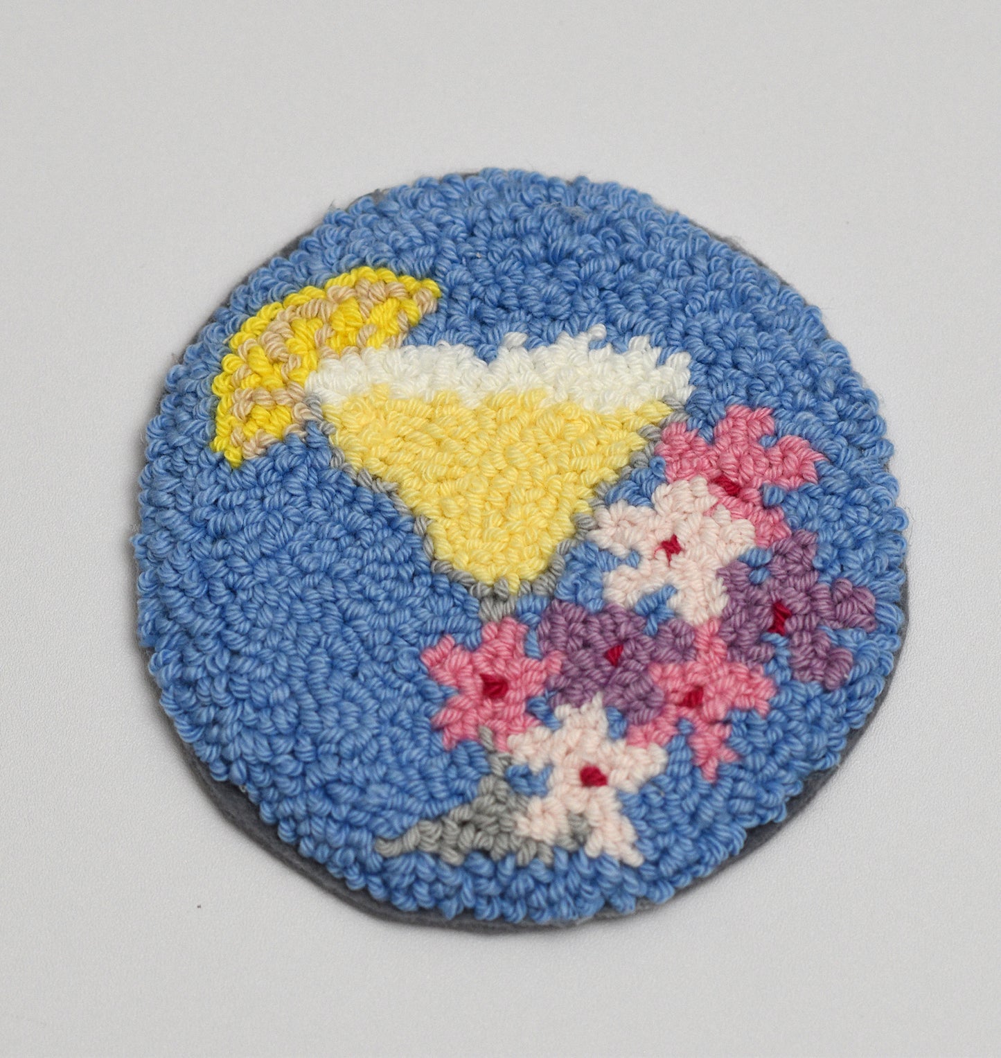Round woven coaster with a Margarita Cocktail design on a gray background