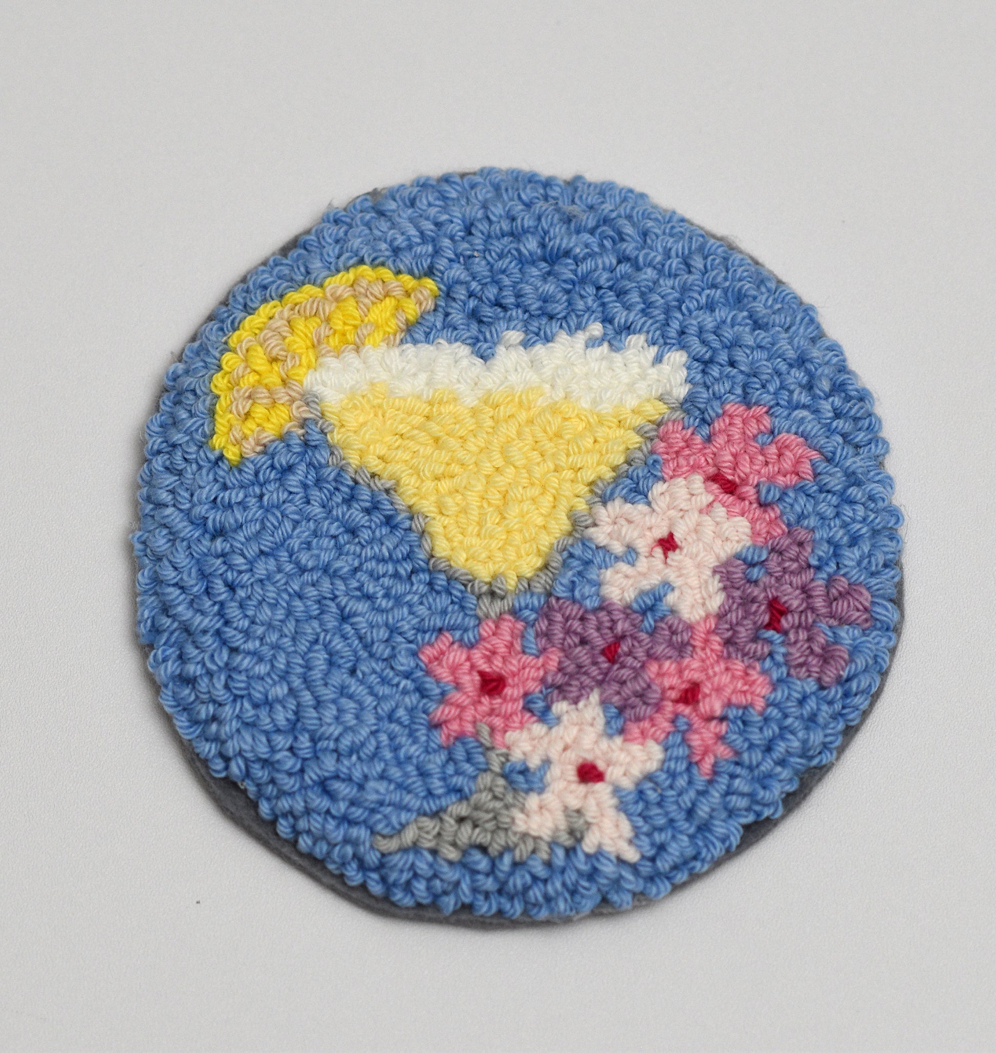 Round woven coaster with a Margarita Cocktail design on a gray background