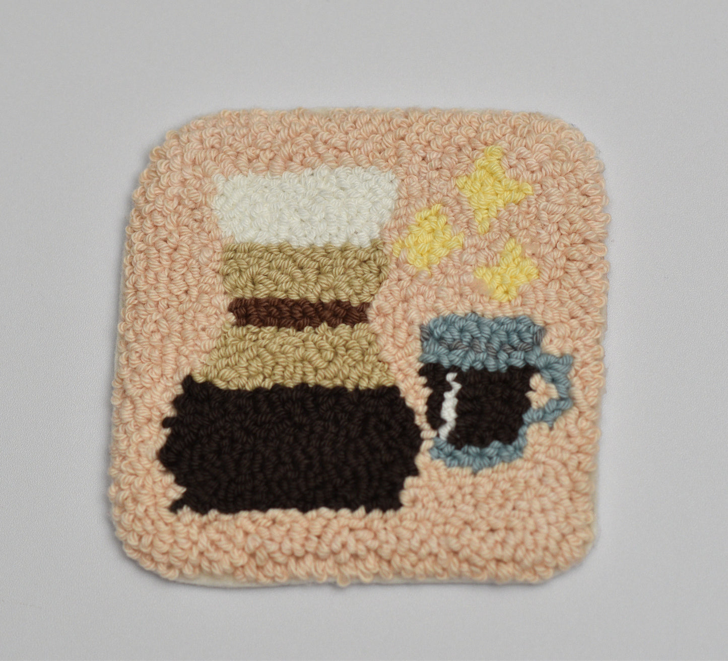 Textured square mug rug with coffee-themed design including chemex on a gray background