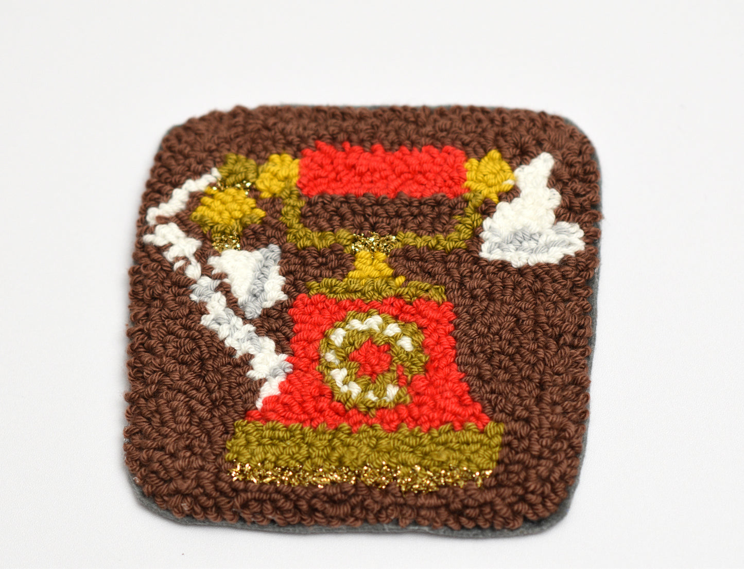 Square coaster with a red telephone design on a brown background