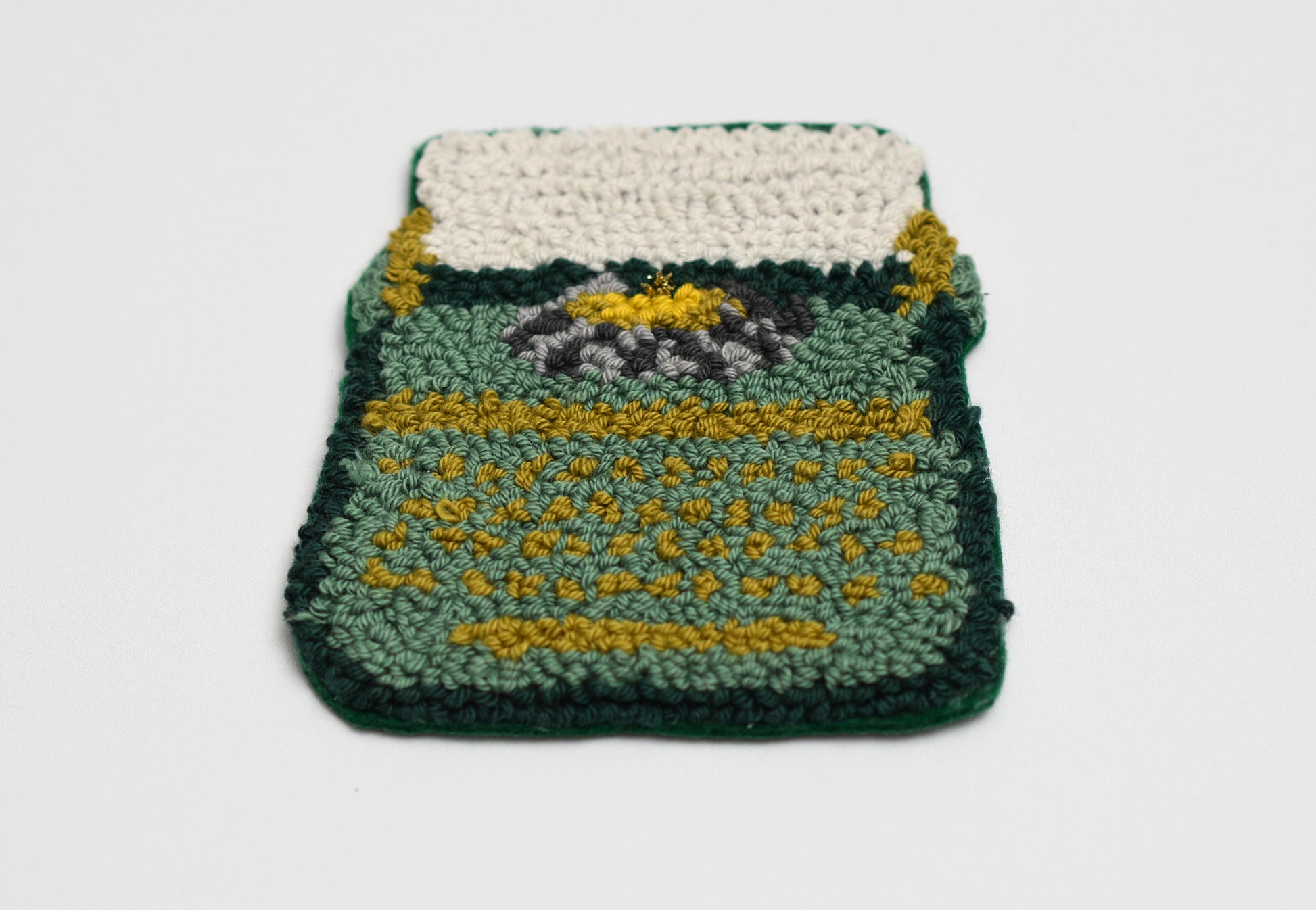 Embroidered coaster with Typewriter design with green and yellow pattern on a white background
