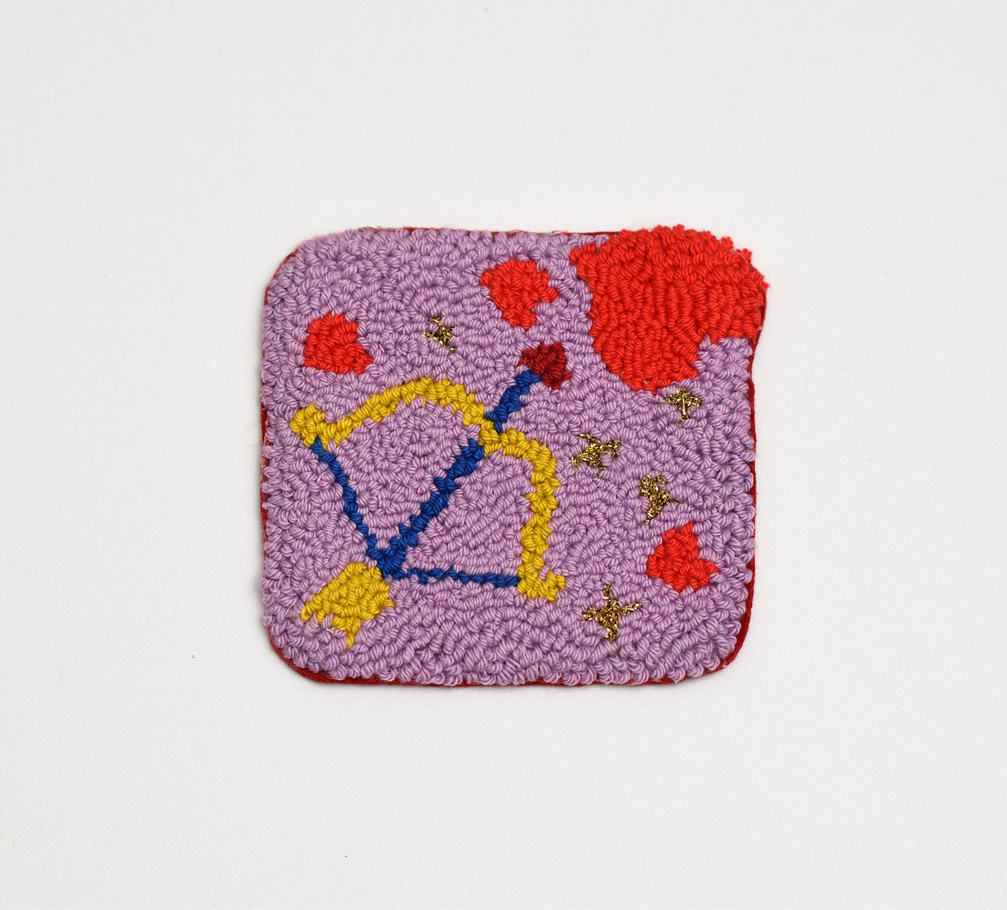 Square textured coaster with colorful cupids bow and hearts design on a light gray background