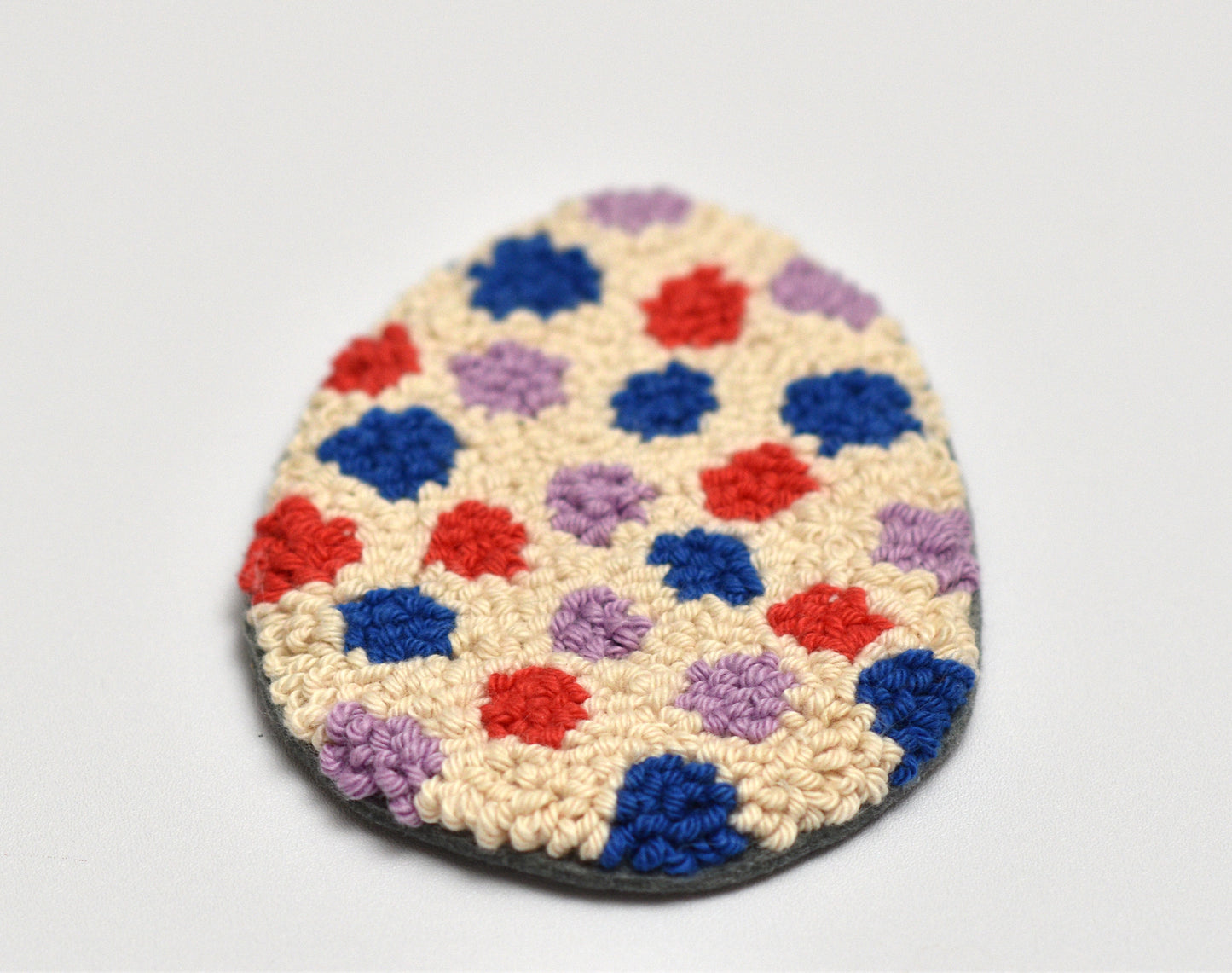 Round textured rug with Easter Egg design and inside colorful dot patterns on a light gray background