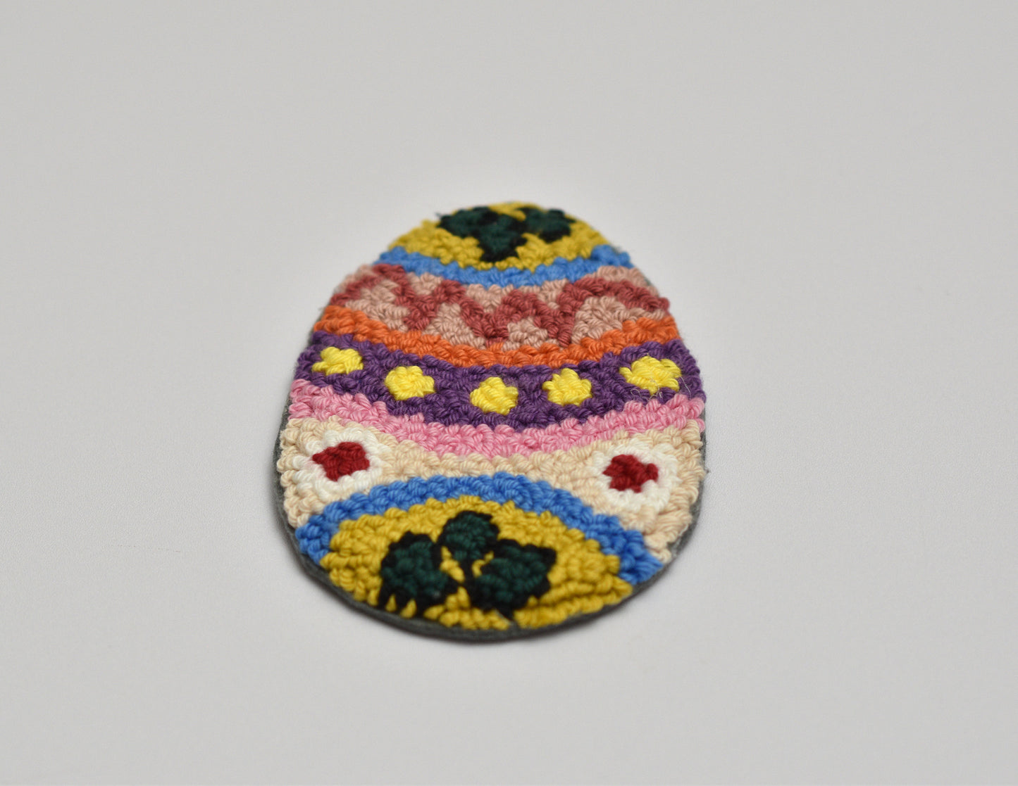 Colorful woven egg-shaped oaster on a gray background