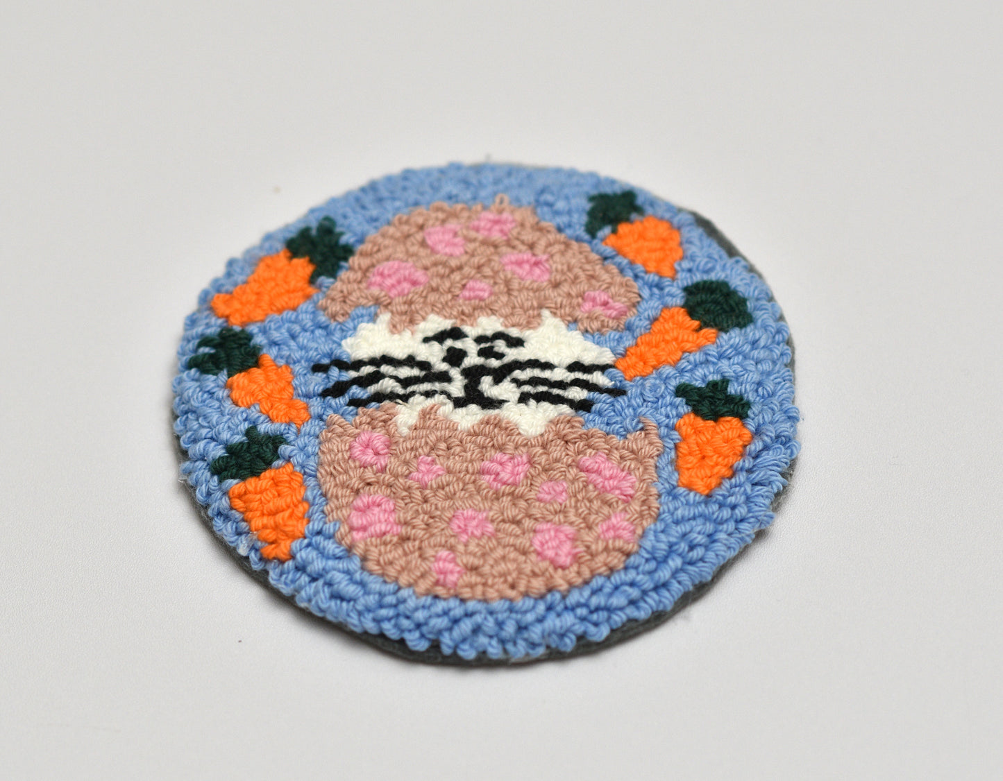 Round embroidered coaster with a Bunny design on a light gray background