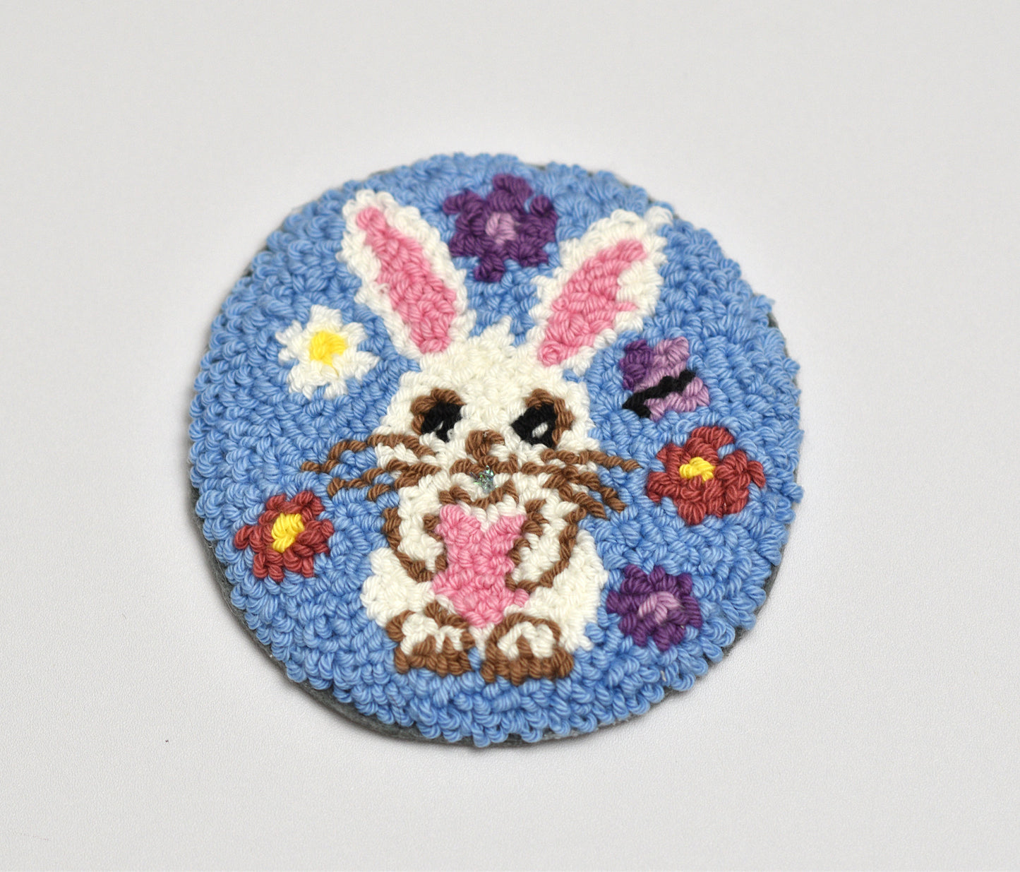 Round blue rug with an Easter bunny design on a light gray background