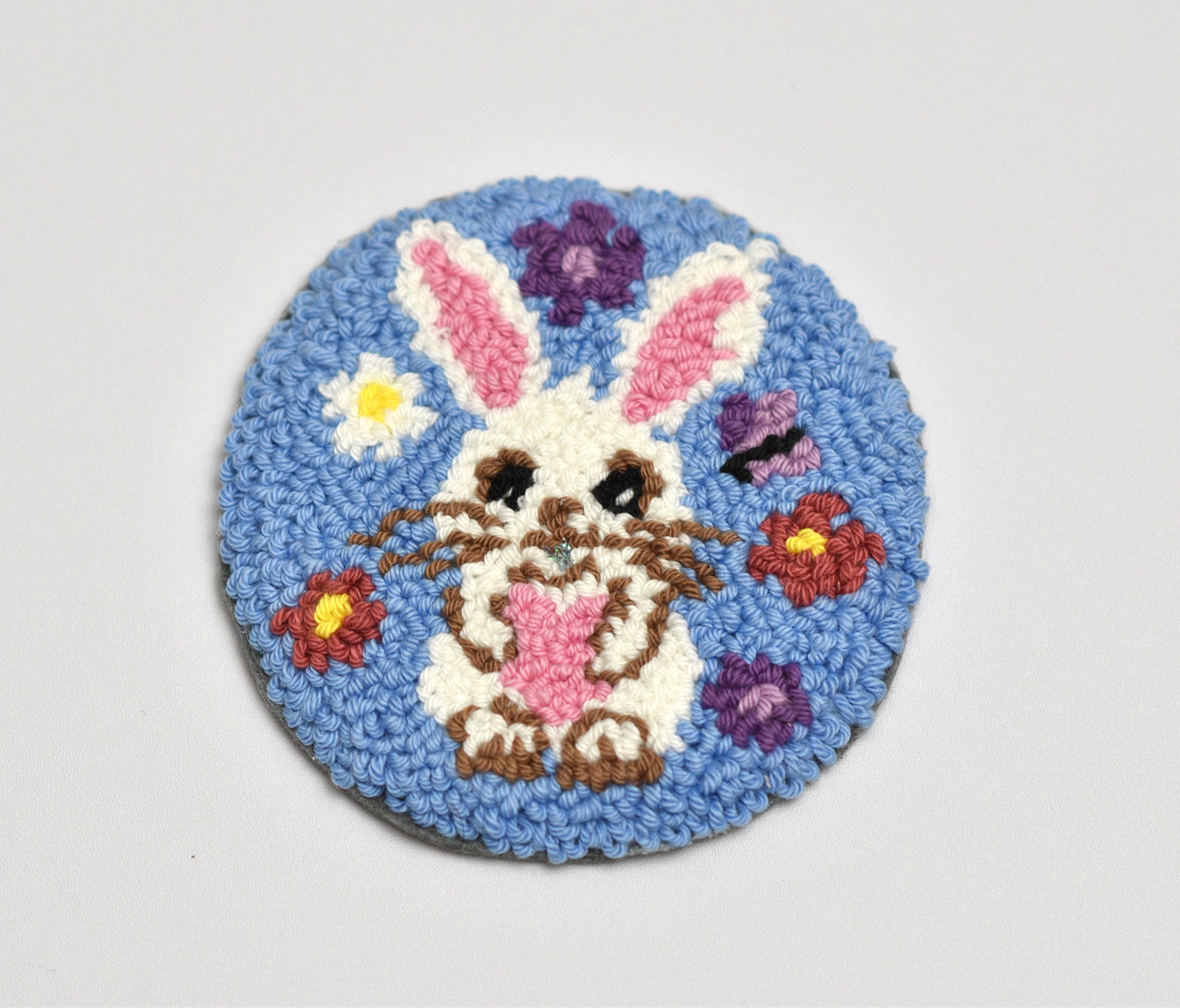 Round blue rug with an Easter bunny design on a light gray background