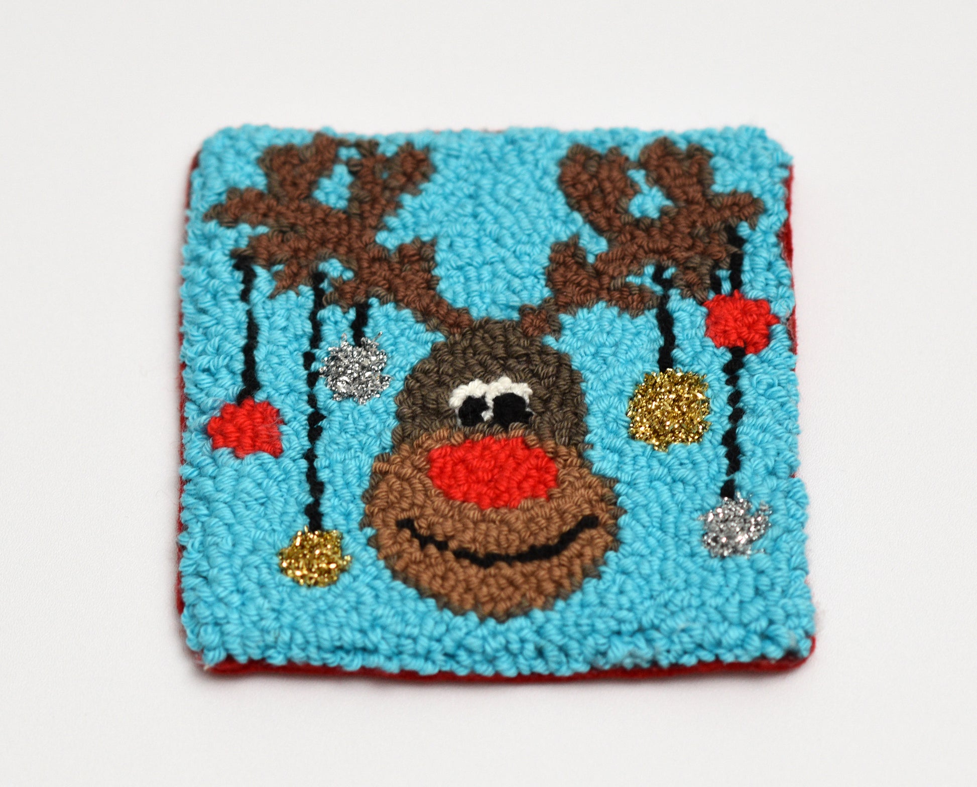 Decorative coaster with a reindeer design on a blue background
