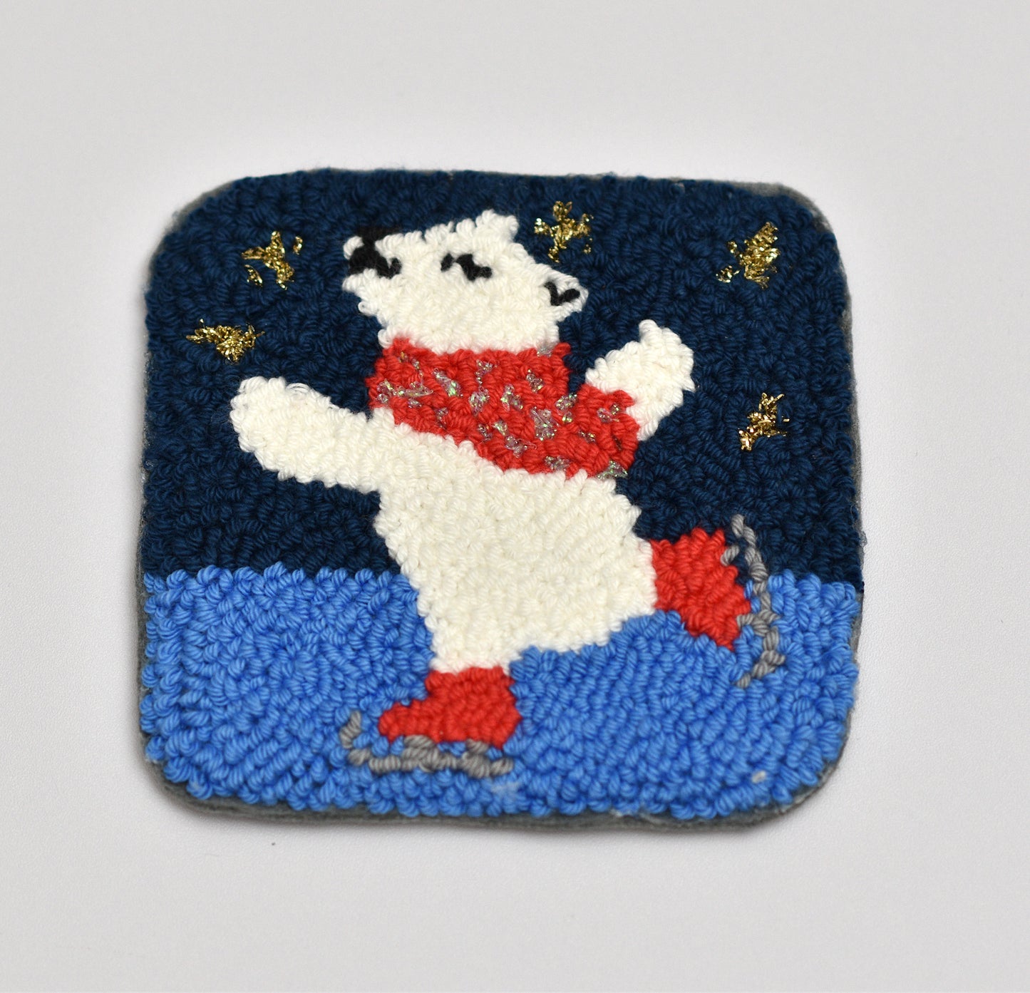 Polar bear coaster with red scarf on a blue and navy background