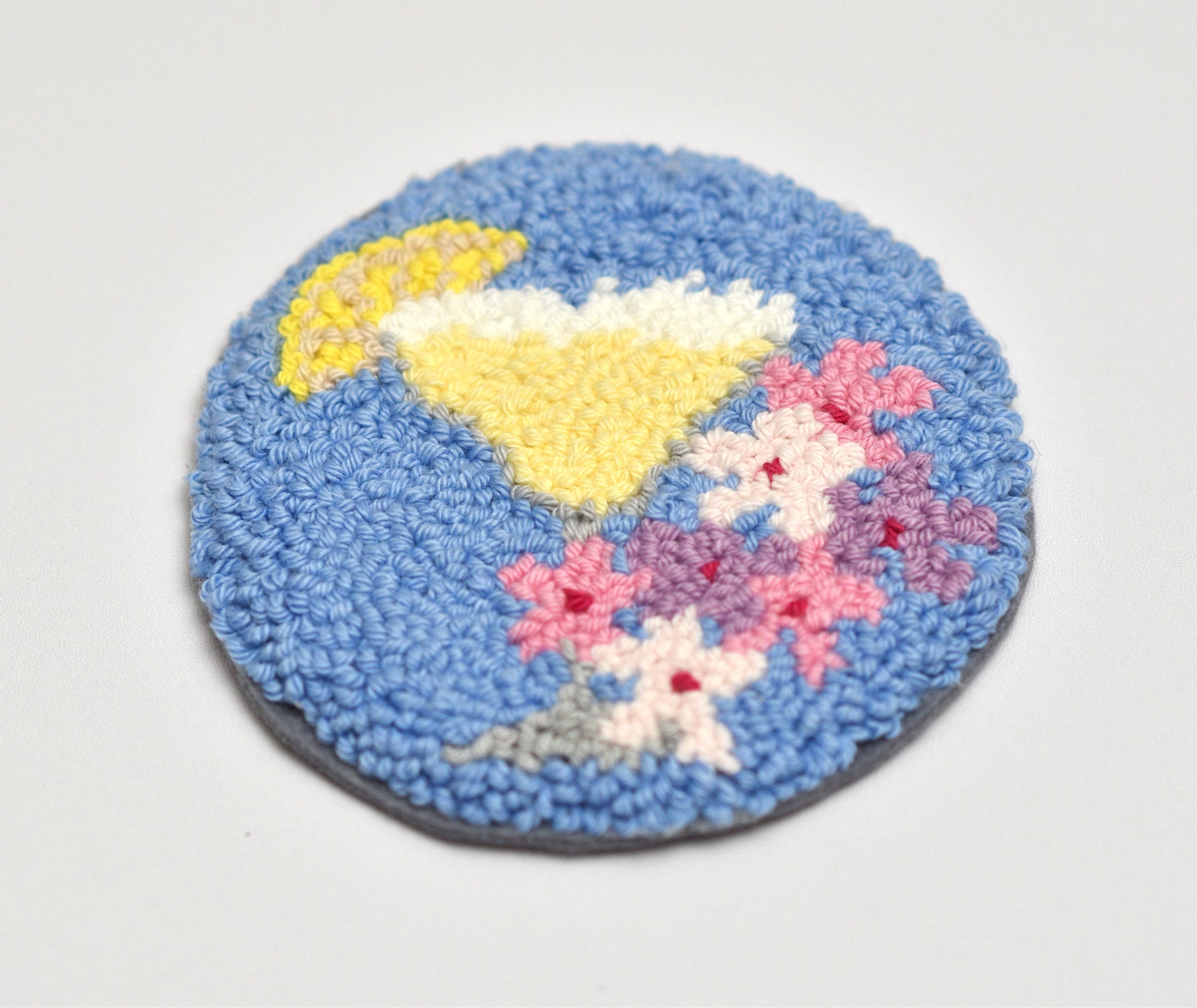 Round blue mug rug with a Margarita cocktail  and yellow lemon slice and pink flowers design on a white background