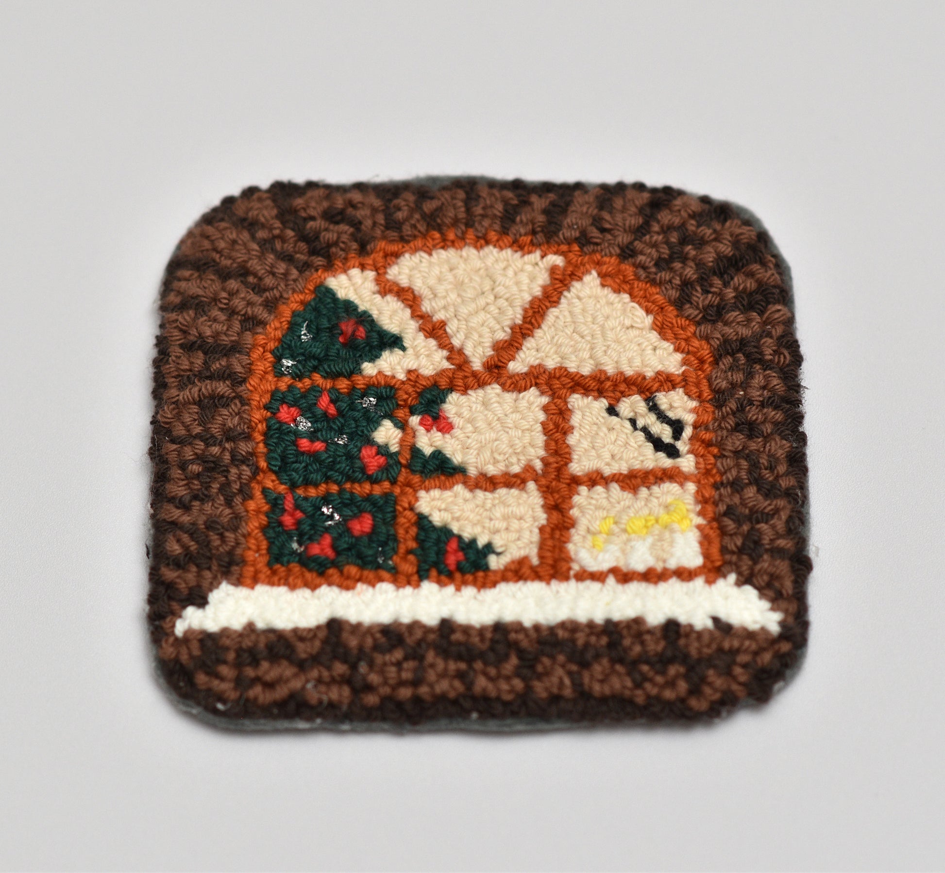 Decorative mug rug with a winter scene design on a plain background