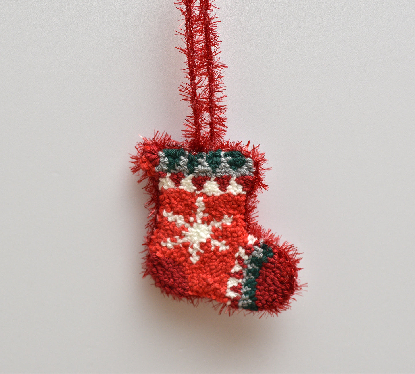 Red Christmas stocking ornament on a light gray background