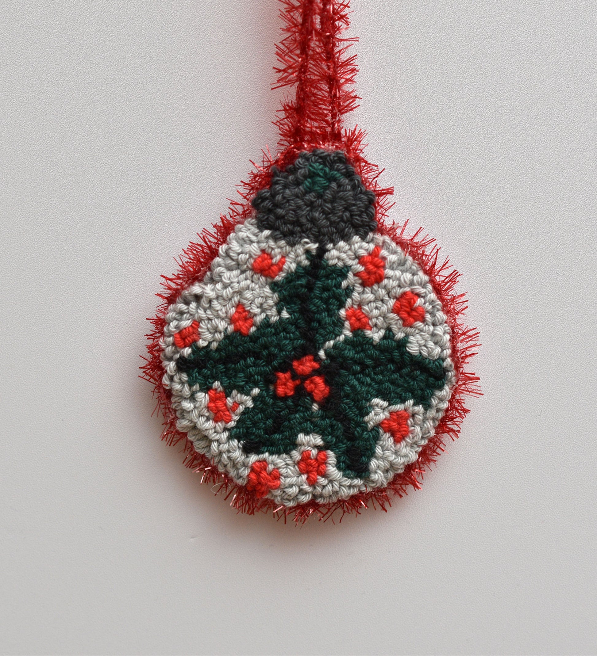 Decorative Christmas ornament with mistletoe design on a plain background