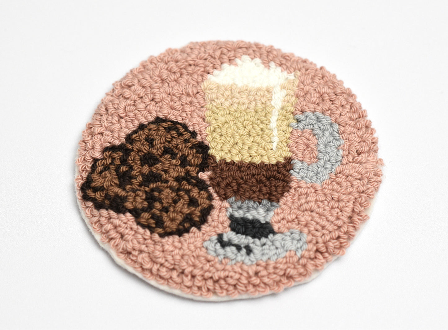 Round coaster with a coffee-themed design featuring a cup, cookie, and milk.