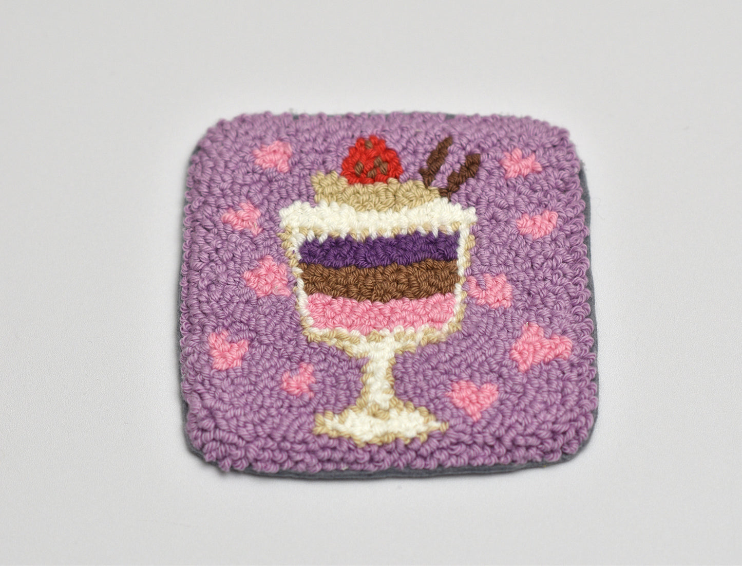 Decorative coaster with a parfait dessert design on a purple background