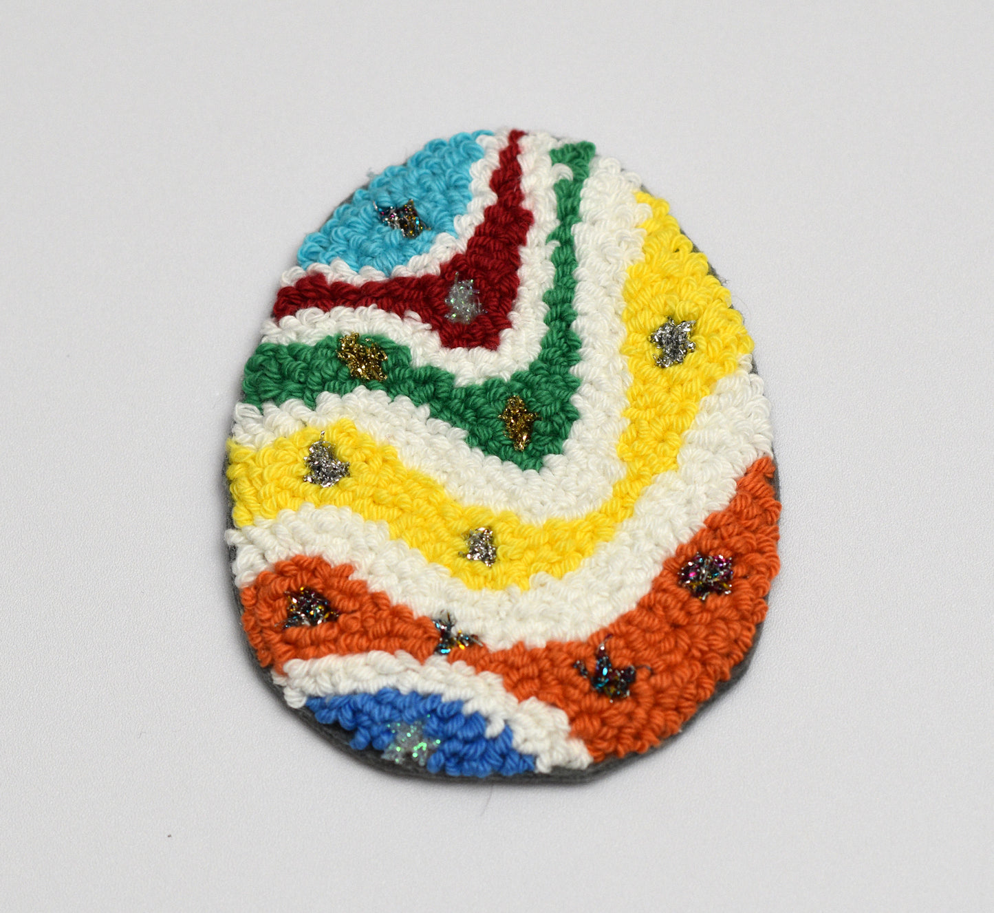 Colorful woven coaster with a zigzag pattern on a white background