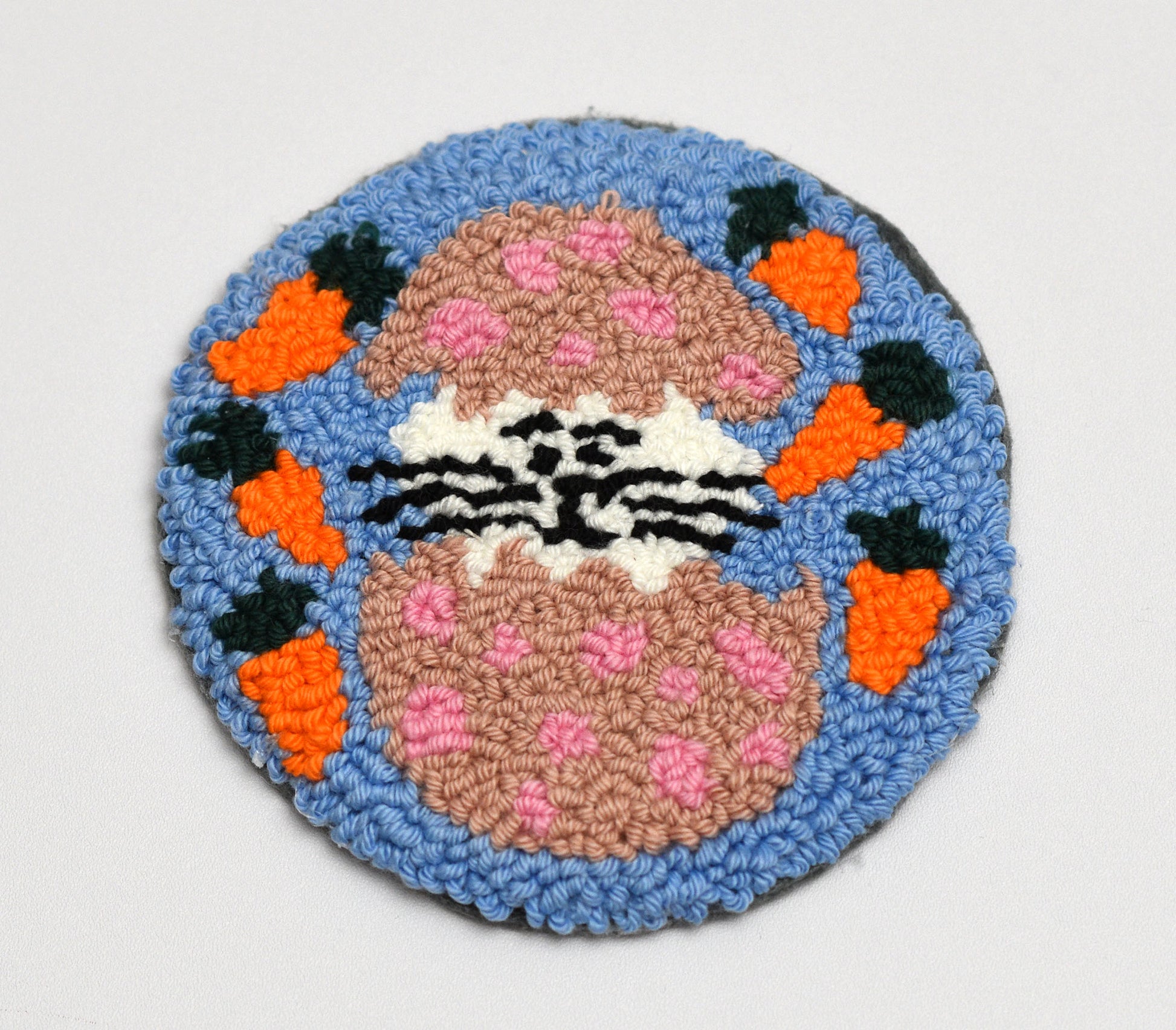 Circular Easter coaster with a Bunny inside Easter Egg design on a blue background