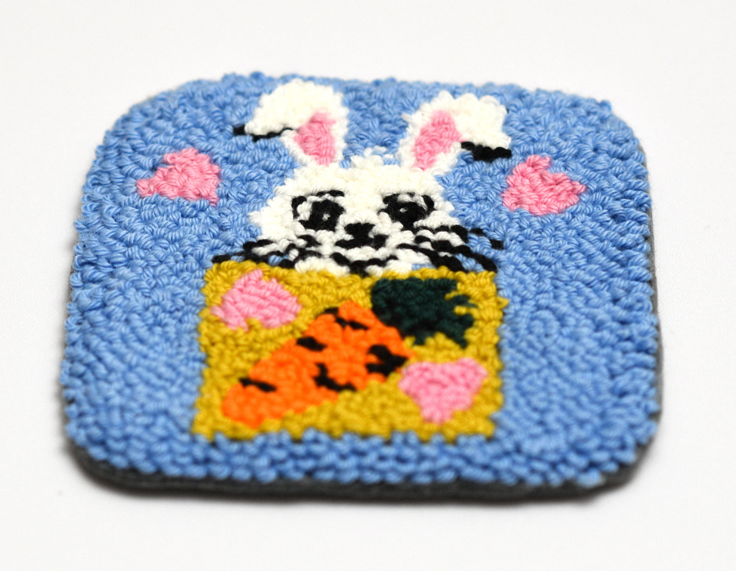Square textured coaster with a bunny design on a blue background