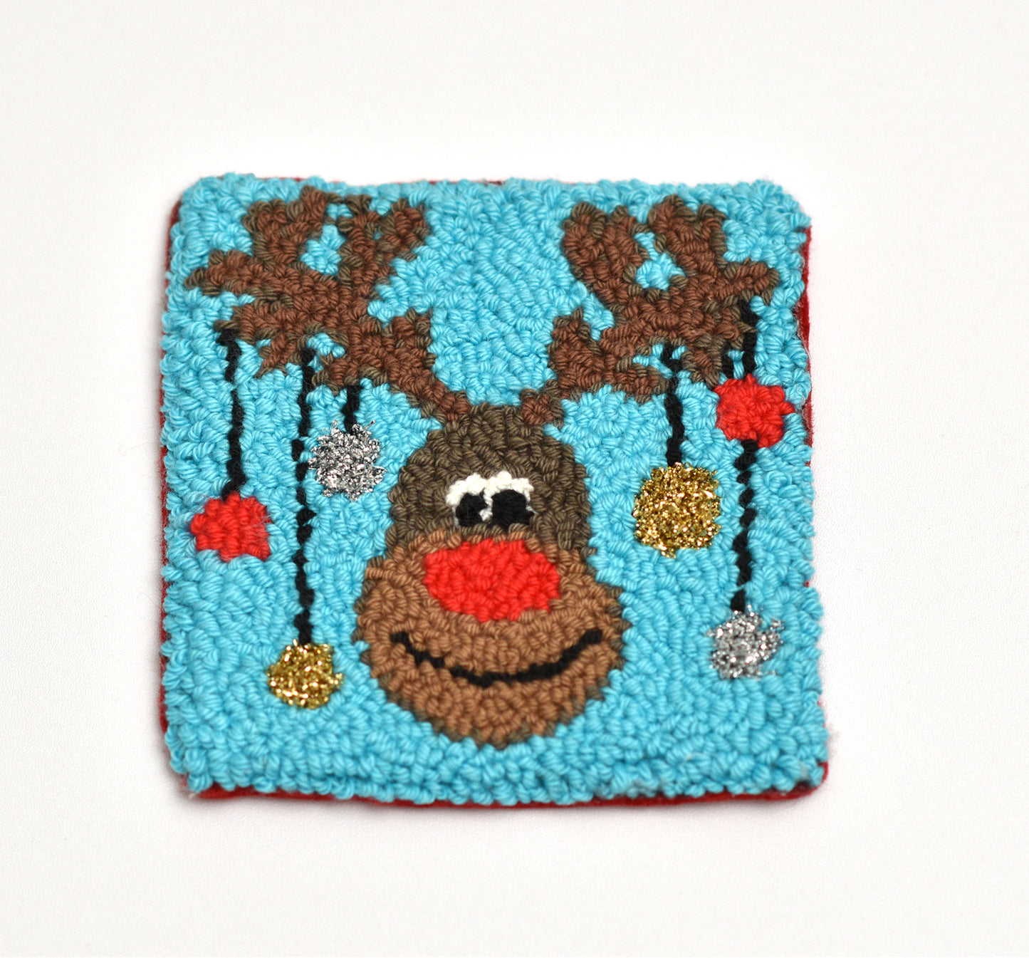 Decorative coaster with a reindeer design on a blue background