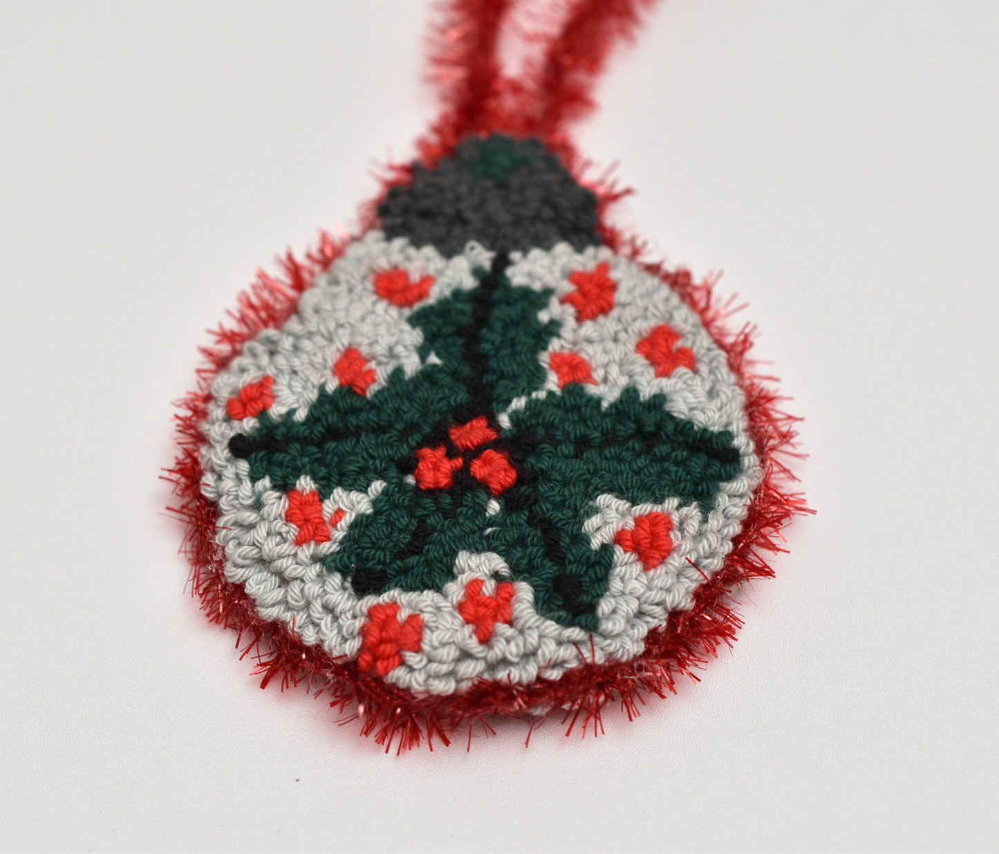 Handmade Christmas ornament with mistletoe design on a white background