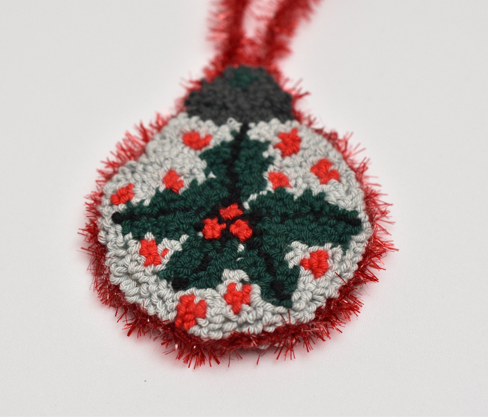 Handmade Christmas ornament with mistletoe design on a white background