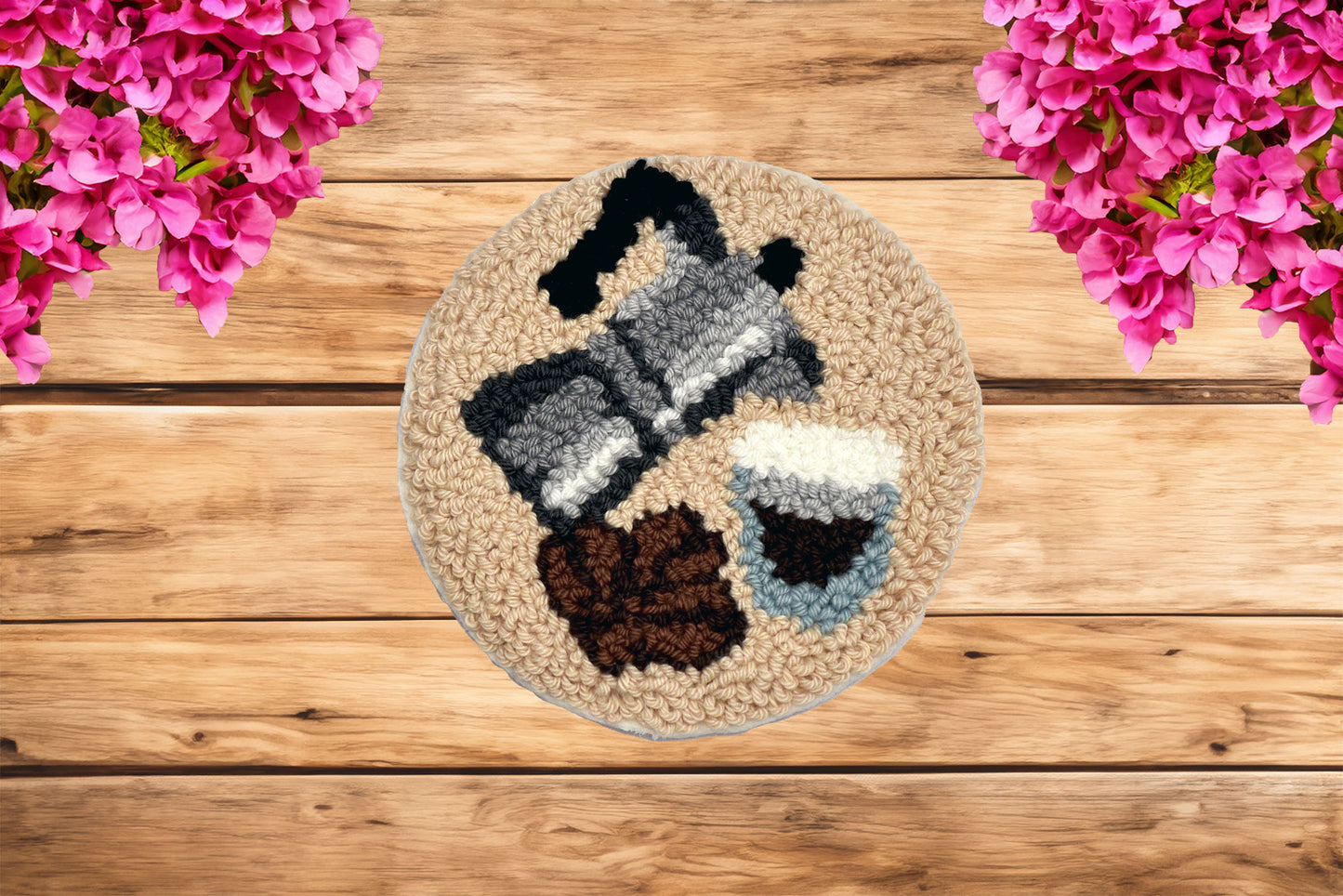 Round woven rug with a coffee-themed design on a wooden surface with pink flowers.